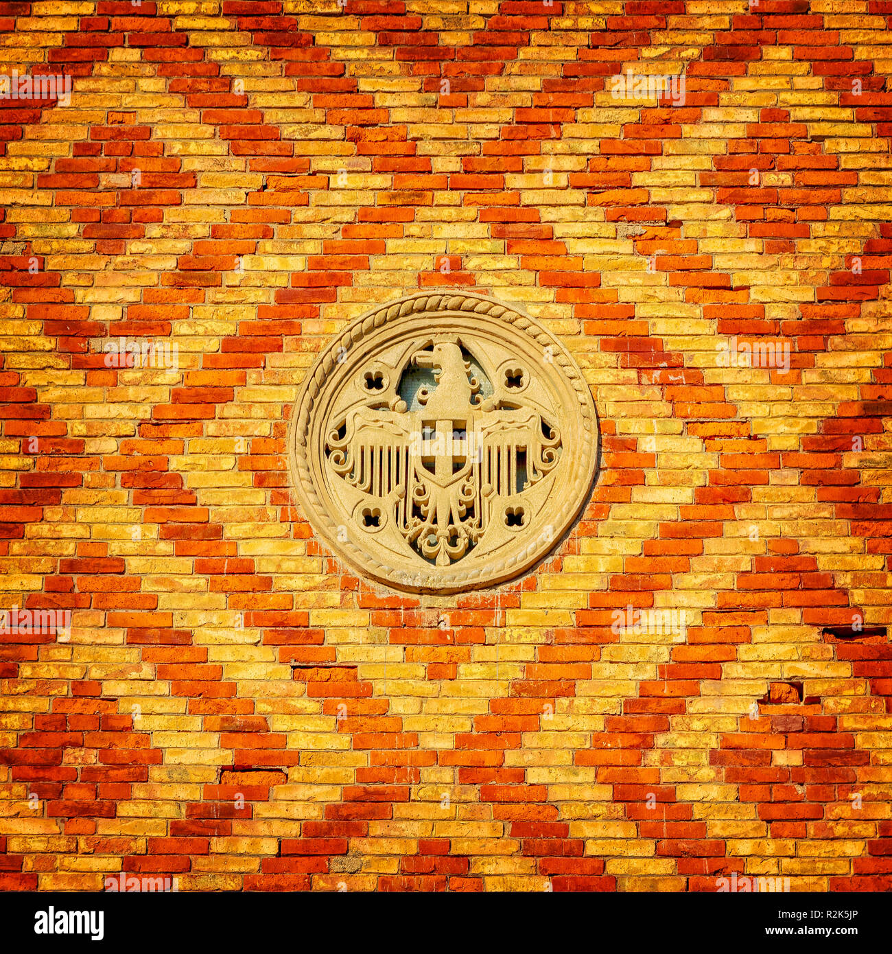 Un mur de brique à motifs ornés d'une décoration en pierre blanche. Banque D'Images