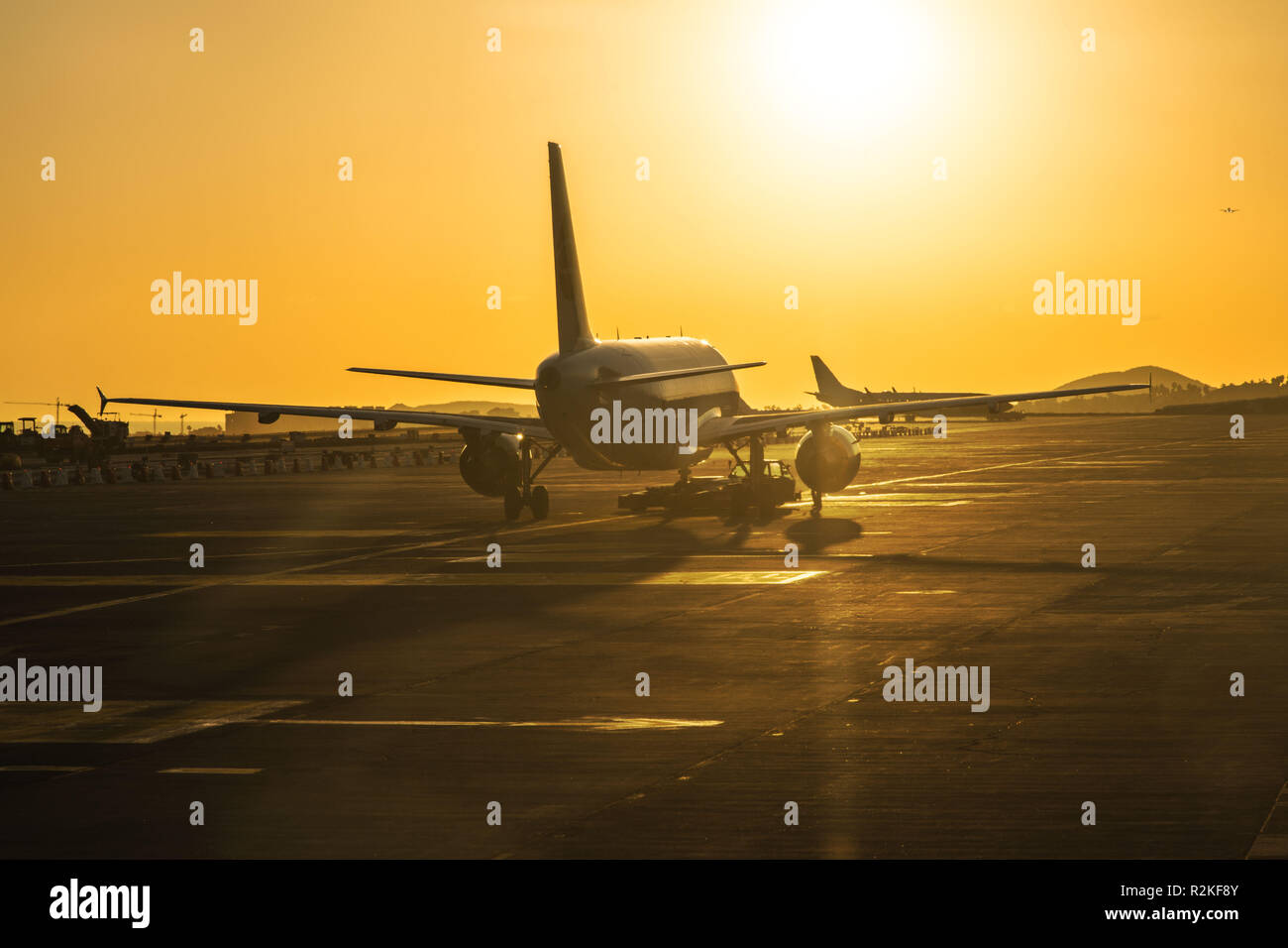 Les avions sur la piste d'un aéroport juste avant le coucher du soleil. Banque D'Images