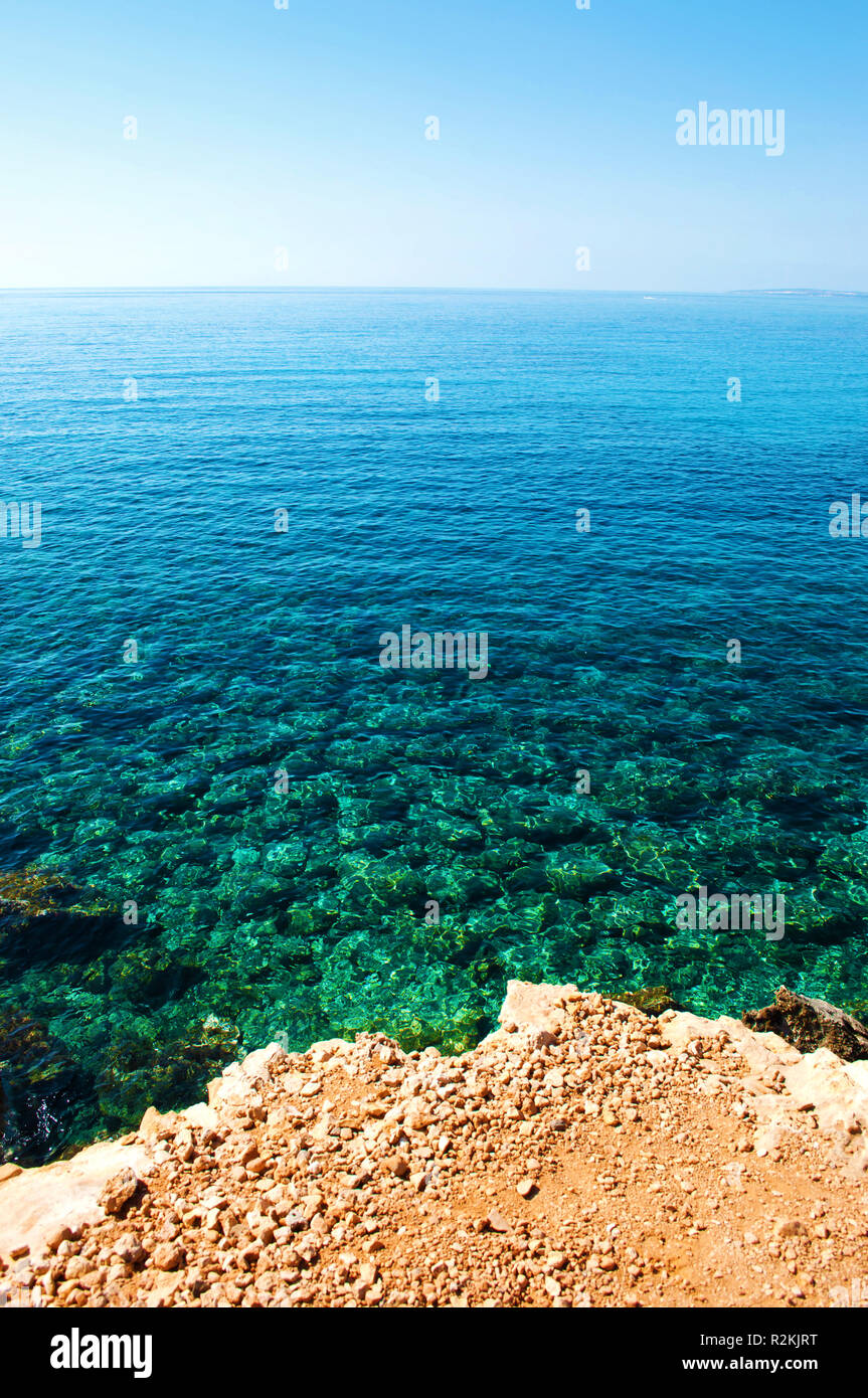 Arrière-plan de pierres jaunes et blancs près de crystal clear ridée transparent incroyable vert et bleu de l'eau sous le bleu ciel sans nuages. Somme sans nuages chauds Banque D'Images