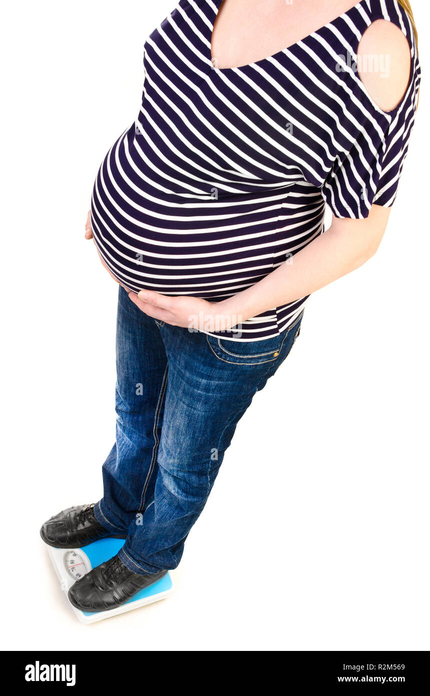 Femme enceinte sur un pèse-personne isolé sur fond blanc Photo Stock - Alamy