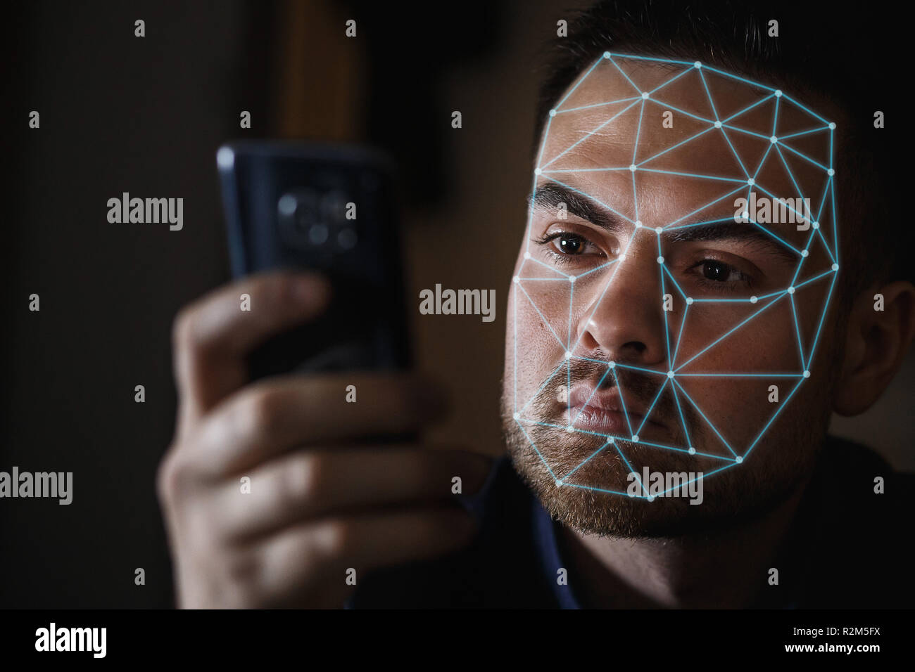 Homme barbu avec le smartphone en utilisant le système de reconnaissance de visage ID. Banque D'Images