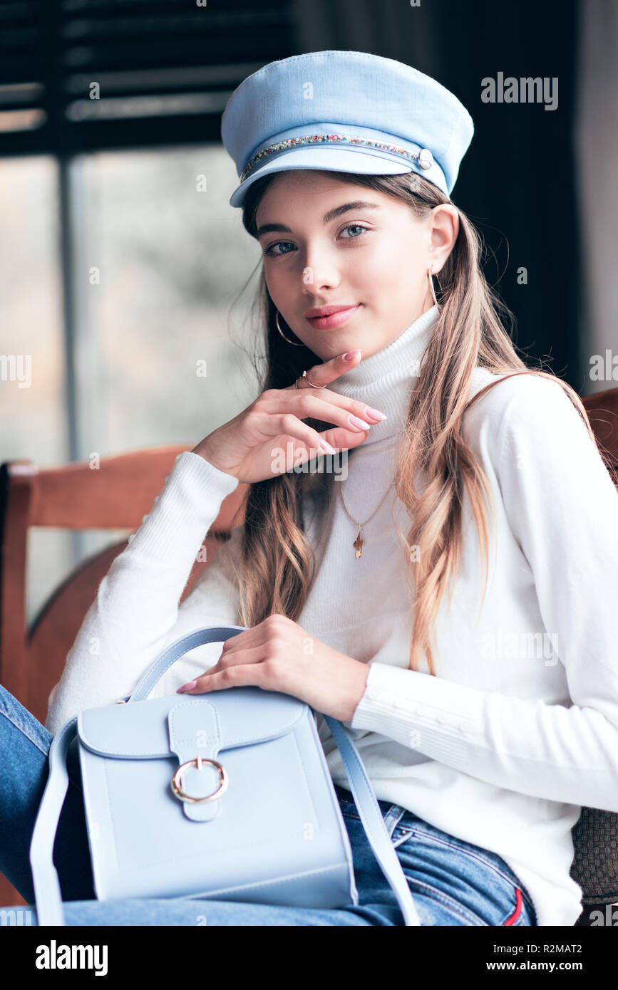 Photo d'une jeune fille belle, dans des tons lumineux. Fille assise sur une chaise. Tonifiant à la mode dans des tons de gris. La tonalité de l'image. Banque D'Images