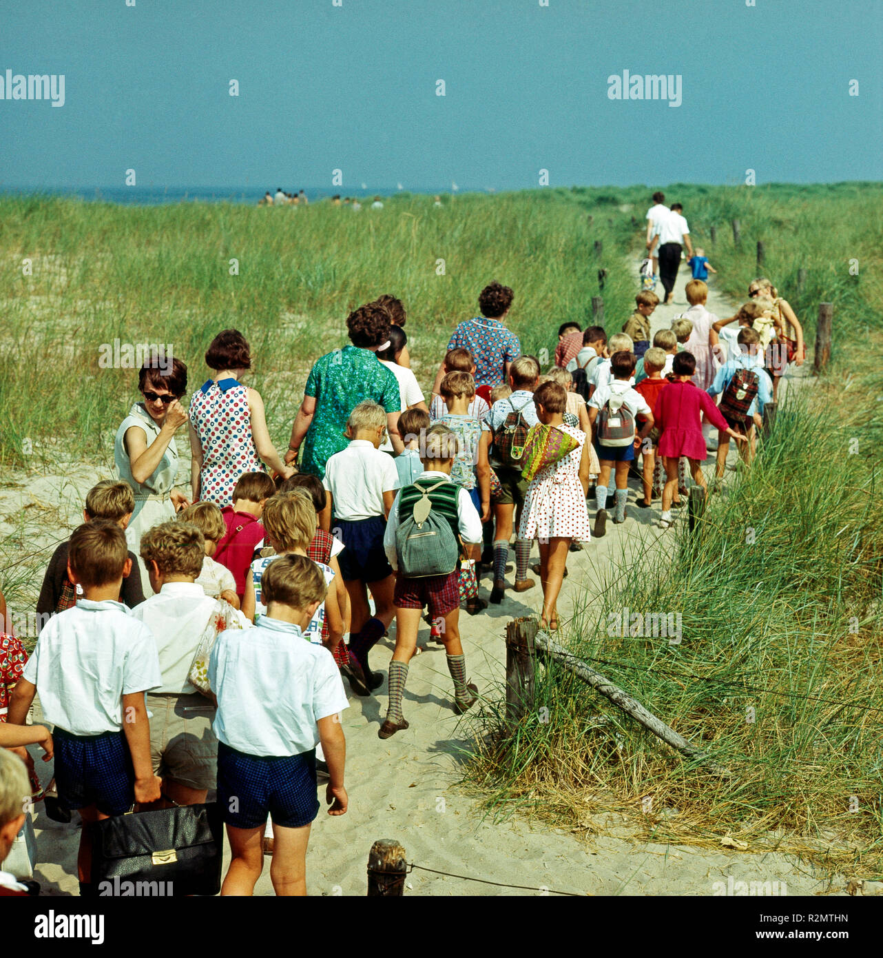 GDR été, les enfants d'un camp de vacances avec les soignants sur le chemin de la plage de sable de Warnemünde Banque D'Images