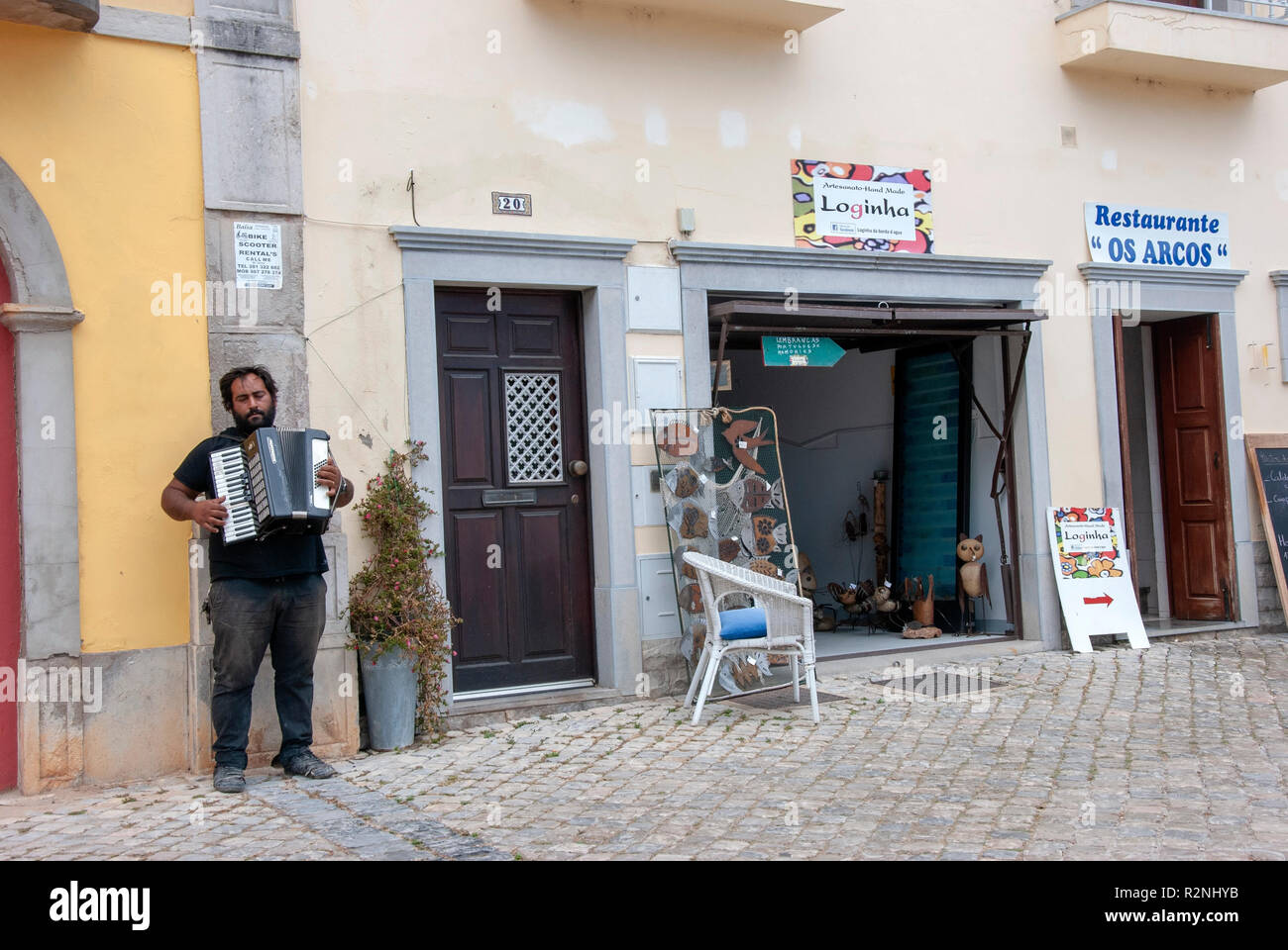 Busker Poruguese jouant accordéon dans la rue pavée Tavira Portugal portugais teint foncé avec des cheveux noirs de l'homme musicien musicien ambulant de la rue barbe mendiant Banque D'Images