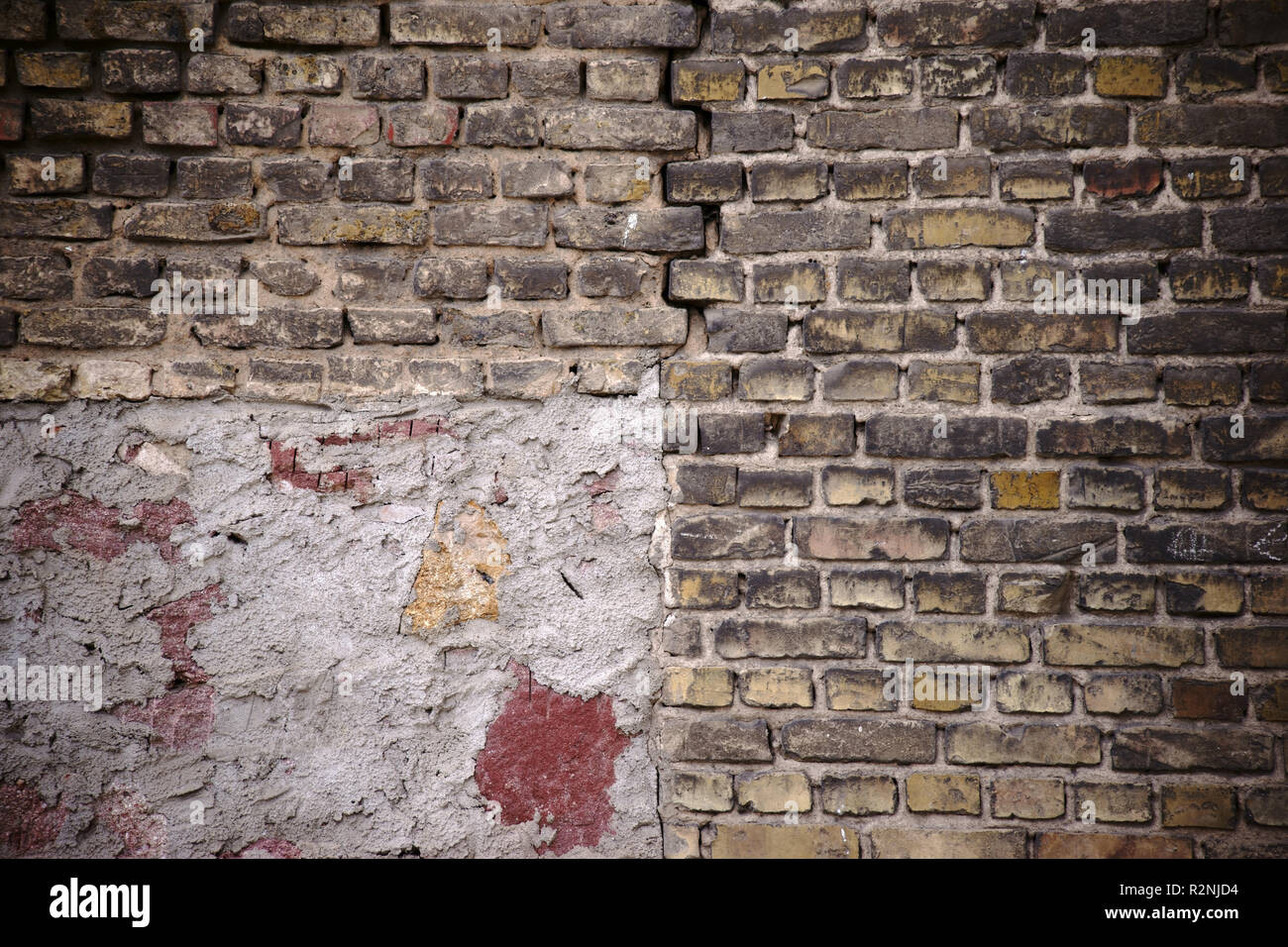 Mur rustique en danger d'effondrement de échelonnés et casse des briques avec une fissure et points de réparation, Banque D'Images