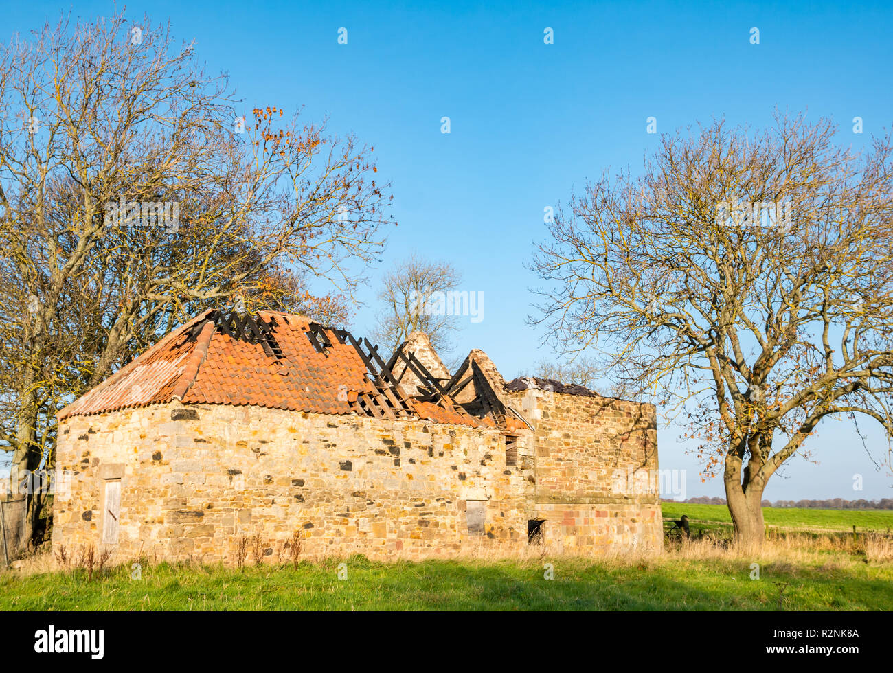 Bâtiment en pierre abandonnée sur le terrain avec le toit effondré montrant les dégâts causés par le feu le long de la rivière Tyne, East Lothian, Scotland, UK Banque D'Images