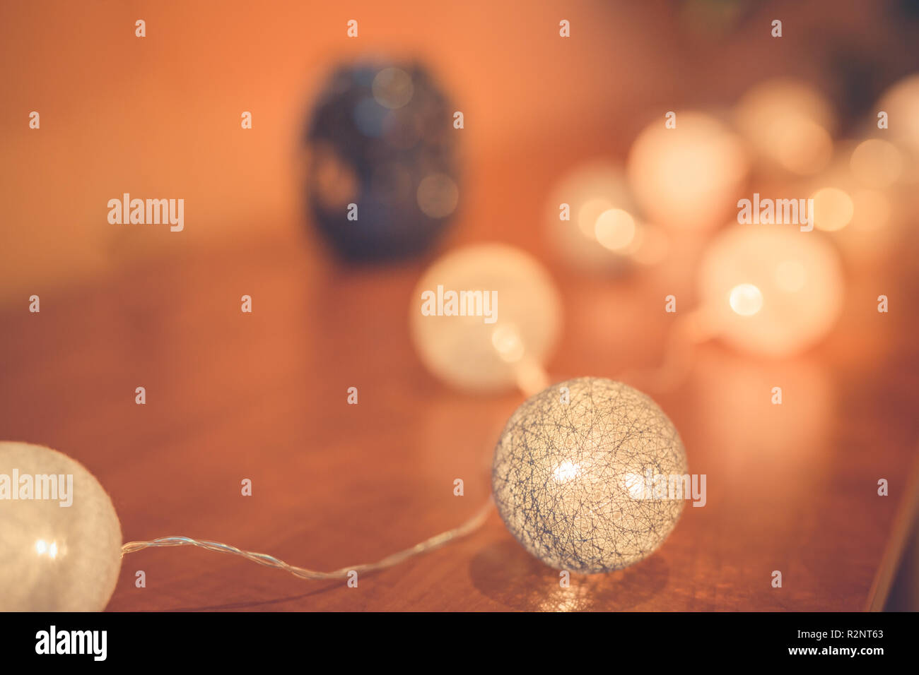 Guirlande lumineuse de boules de coton de Noël et du nouvel an dans un plateau en bois d'époque, sur fond de bois raboté, style rustique minimaliste, gros plan Banque D'Images