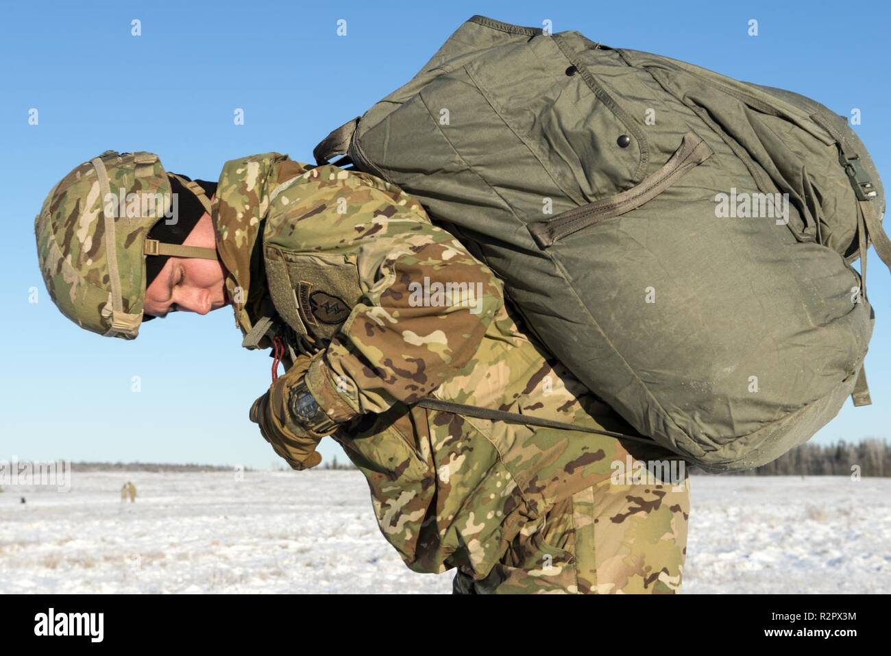 Un parachutiste de l'armée affectés à la 4th Infantry Brigade Combat Team (Airborne), 25e Division d'infanterie de l'armée américaine, l'Alaska, ajuste son parachute pack récupéré après avoir sauté d'un hélicoptère CH-47 Chinook au Joint Base Elmendorf-Richardson, Alaska, le 1 novembre 2018. Les soldats de 4/25 appartiennent à la seule brigade aéroportée américaine dans le Pacifique et sont formés pour exécuter des manœuvres aériennes dans l'extrême froid et environnements de haute altitude à l'appui de combattre, de partenariat et d'opérations de secours en cas de catastrophe. Les aviateurs de l'armée de la Compagnie B, 1er Bataillon, 52e Régiment d'Aviation à Fort Wainwrig Banque D'Images