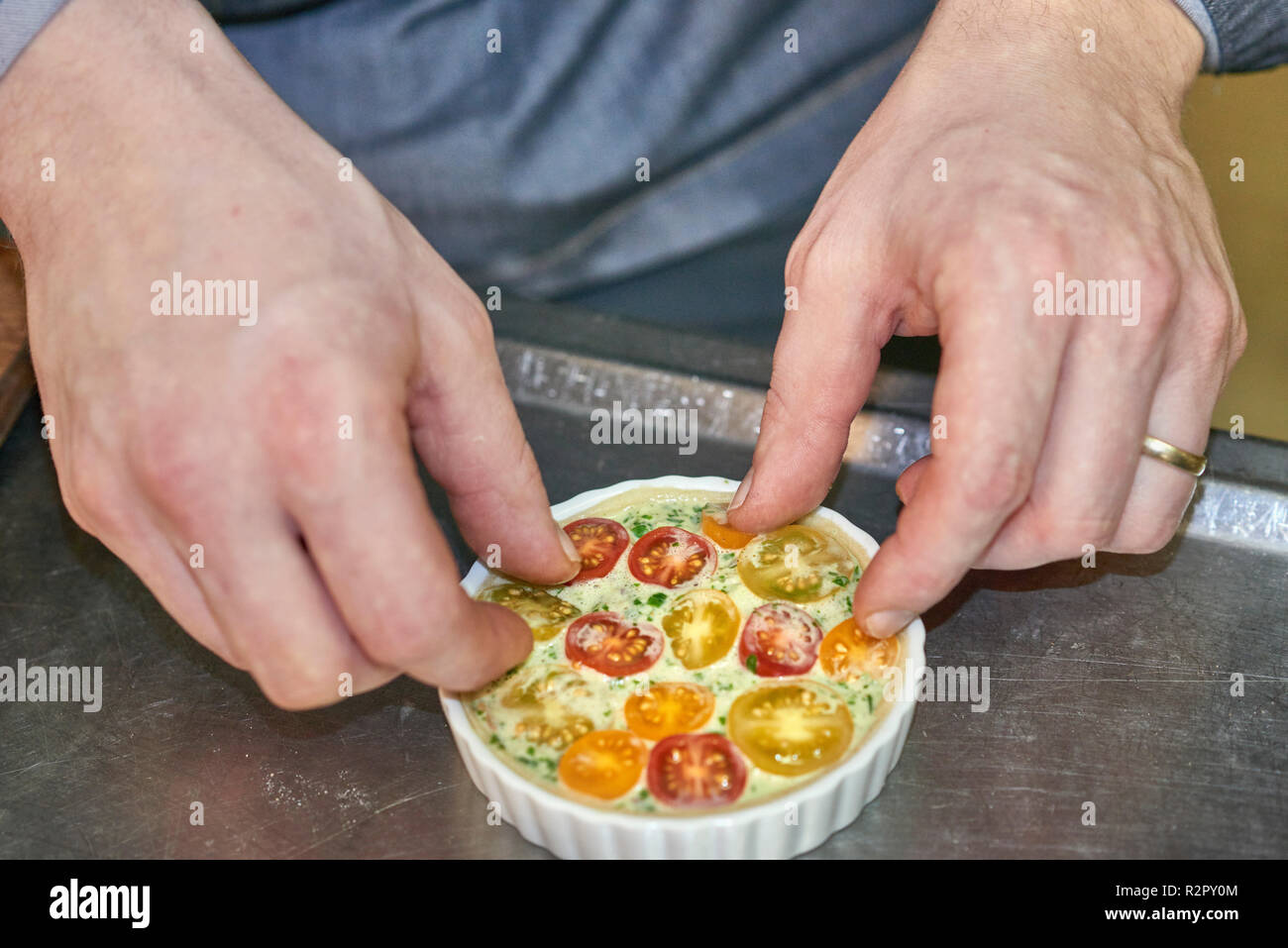 Préparation de mini-tartelettes, décorer avec des tomates cocktail Banque D'Images