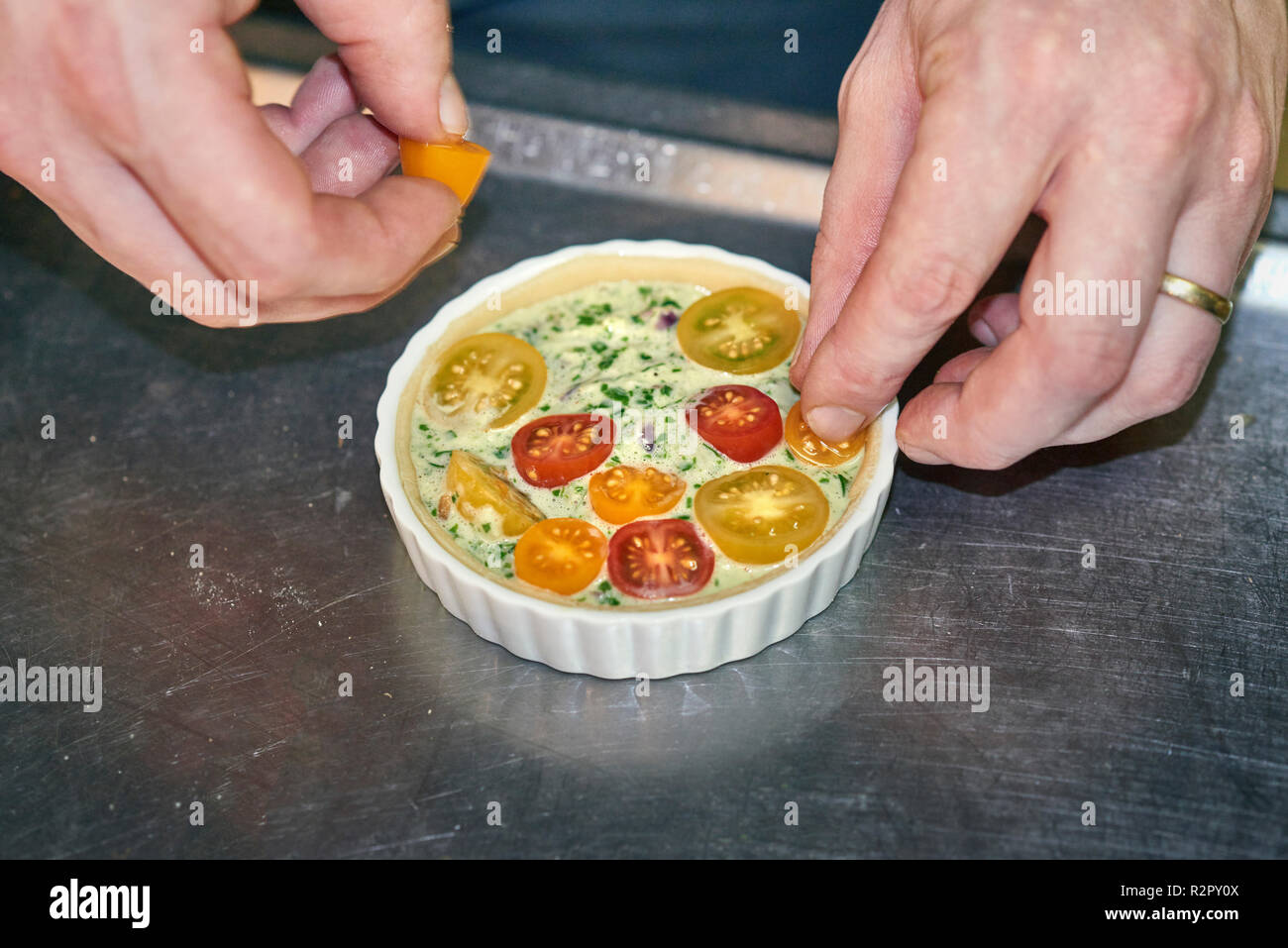 Préparation de mini-tartelettes, décorer avec des tomates cocktail Banque D'Images