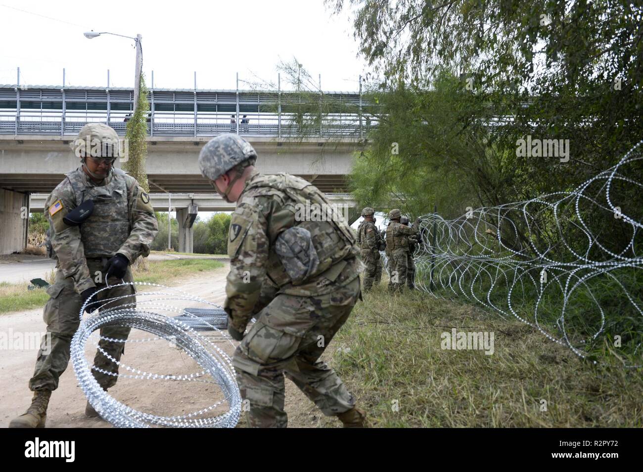 Les soldats de la 97e Brigade de police militaire, et 41e compagnie du génie, Fort Riley, KS., travailler le long du côté avec le U.S. Customs and Border Protection à l'Hidalgo, TX., port d'entrée, l'application de 300 mètres de barbelés le long de la frontière du Mexique à l'appui de l'opération FIDÈLES PATRIOT 2 Novembre, 2018. Les soldats devront fournir diverses formes de soutien, y compris la planification de l'aide, du soutien, de l'équipement et des ressources pour aider le Ministère de la sécurité intérieure le long de la frontière sud-ouest. Banque D'Images