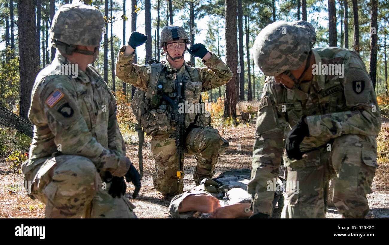 Un combat medic en compétition pour l'expert médical sur le terrain d'un insigne des signaux à son équipe comment bien vous pouvez chercher le 3 novembre, 2018 des dangers, sur Fort Bragg, N.C. La première semaine d'essais présente les candidats de toutes les tâches qu'ils vont s'attendre à remplir pour gagner le badge convoité. L'EFMB a été créé pour faire connaître et reconnaître les soldats pour leur niveau de compétence et la compétence dans le domaine médical. Le test se compose d'un examen écrit, la navigation terrestre, trois voies d'essai de combat et se termine par un 12-mile ruck mars. Banque D'Images