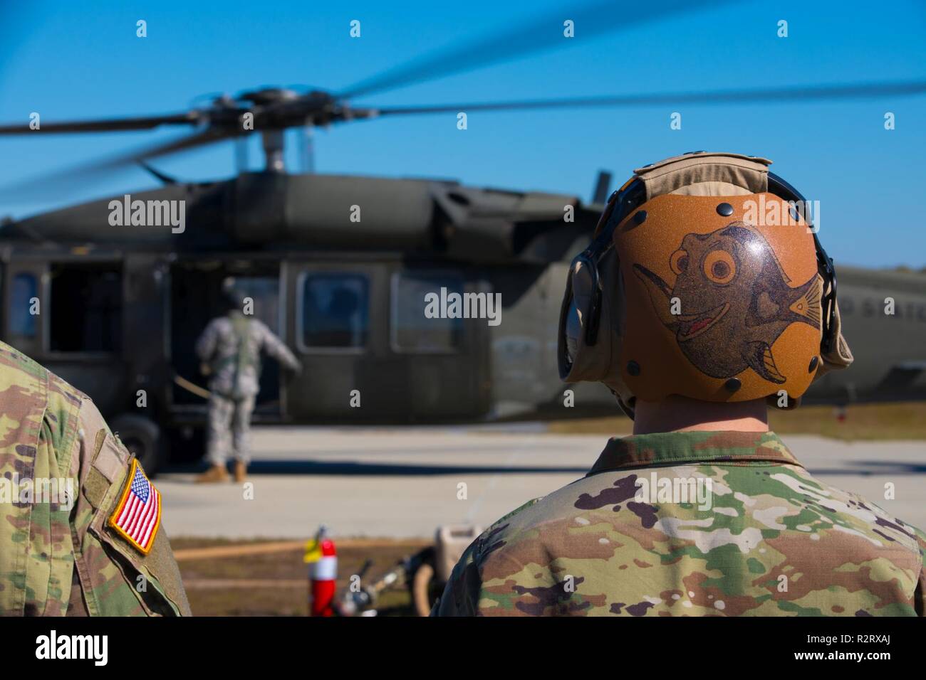 L'ARMÉE AMÉRICAINE Pvt. Charles Stewart Première Classe attribuée à 1/106E Company e bataillon d'hélicoptères d'Assaut (AHB), Georgia National Guard, attend d'refuela Blackhawk UH-60 appartenant à la compagnie C (AHB), à l'aéroport de Bartow Comté, dévidoir en Géorgie, le 3 novembre 2018. Cette formation permet aux deux aviateurs et soldats à perfectionner leurs compétences pour préparer l'avenir le succès de la mission. Banque D'Images