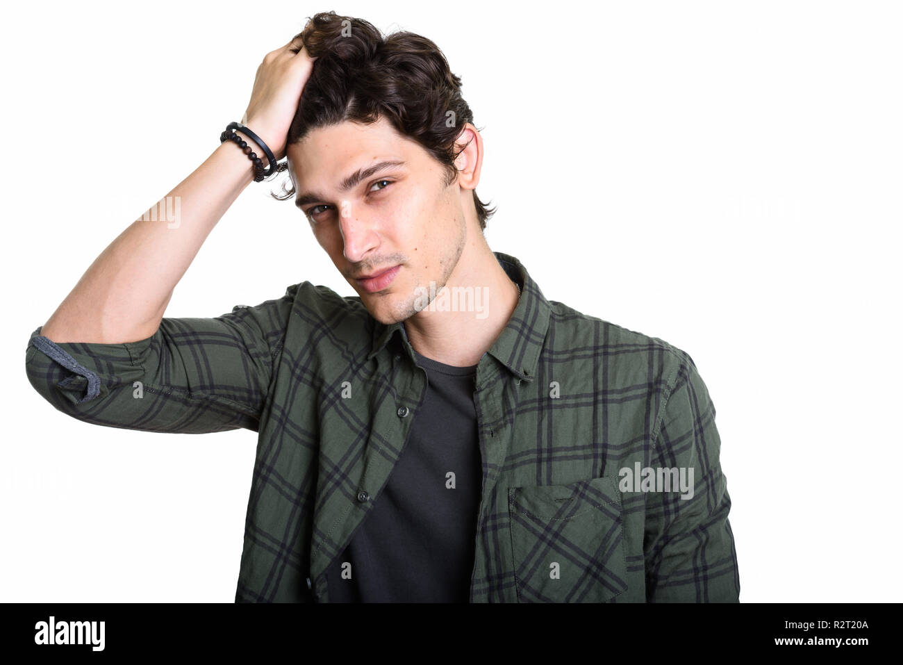 Studio shot of young handsome man brushing cheveux en arrière Banque D'Images