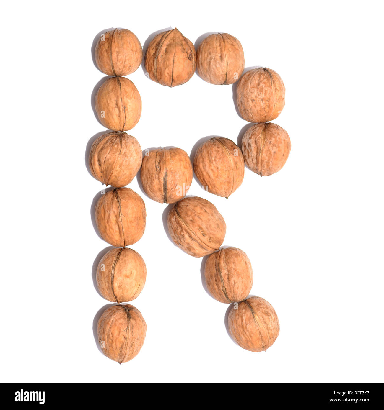 Lettre R faite avec les écrous à la forme d'une lettre de l'alphabet. Lettres de fruits sur un fond blanc. Banque D'Images
