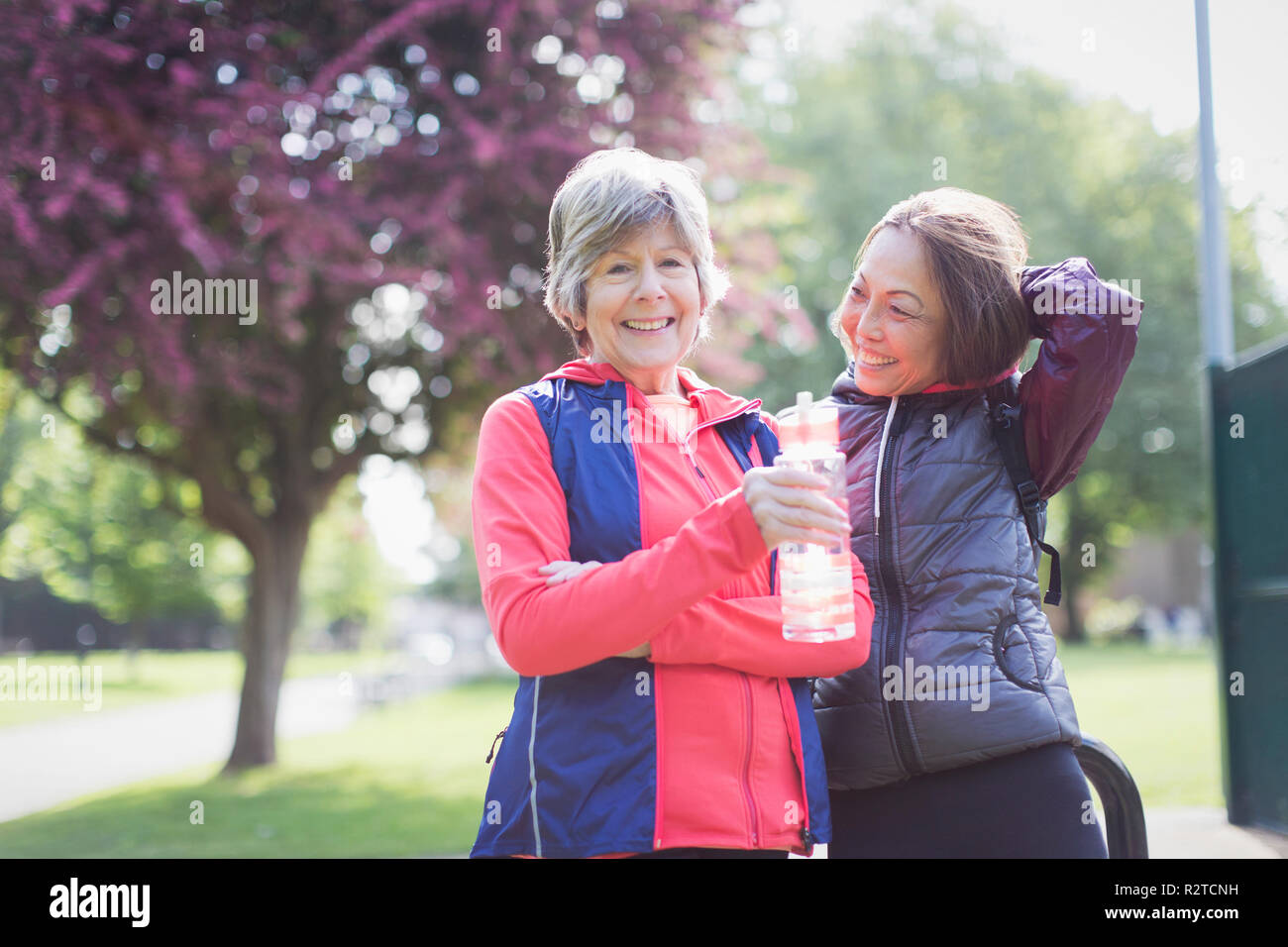 Portrait confiant senior female runner les amis de l'eau potable dans park Banque D'Images