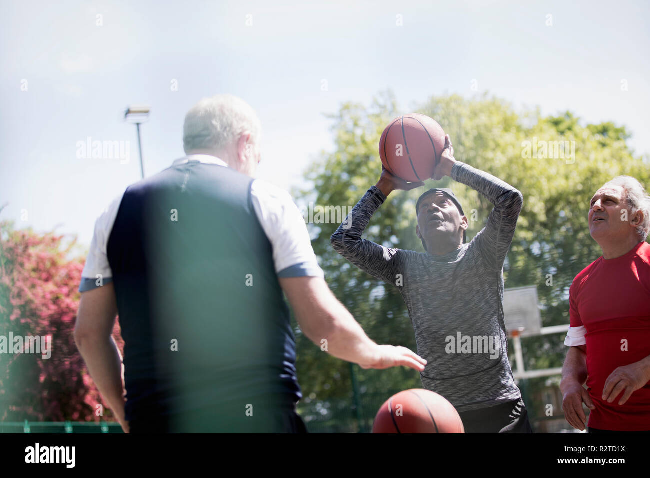Senior hommes jouant au basket-ball à sunny park Banque D'Images