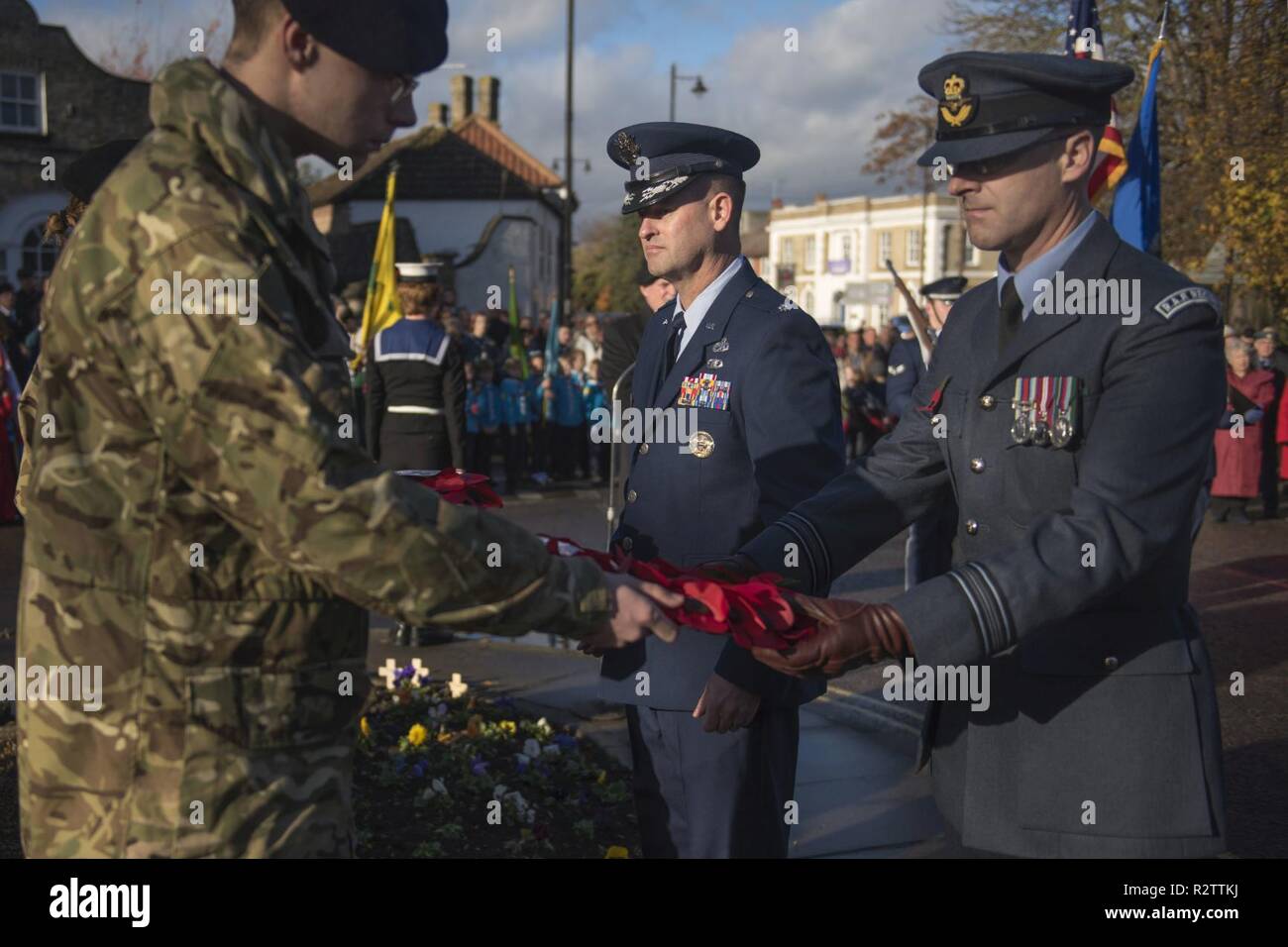 Le Lieutenant-colonel de l'US Air Force Ryan White, 100e groupe de maintenance sous-commandant de groupe et de la Royal Air Force Sqd. Ldr. Paul Graham, RAF Mildenhall commandant de station passer une couronne de pavot à être mis sur le monument commémoratif de guerre du Canada au cours du Jour du Souvenir à Mildenhall, Angleterre, le 11 novembre, 2018. White et Graham présente la ville avec une couronne de fleurs de pavot en souvenir de la Première Guerre mondiale, au nom de l'équipe de Mildenhall aviateurs et membres du personnel civil. Banque D'Images