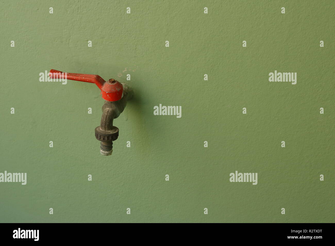 Photo gros plan de l'ancien robinet du mur vert Banque D'Images