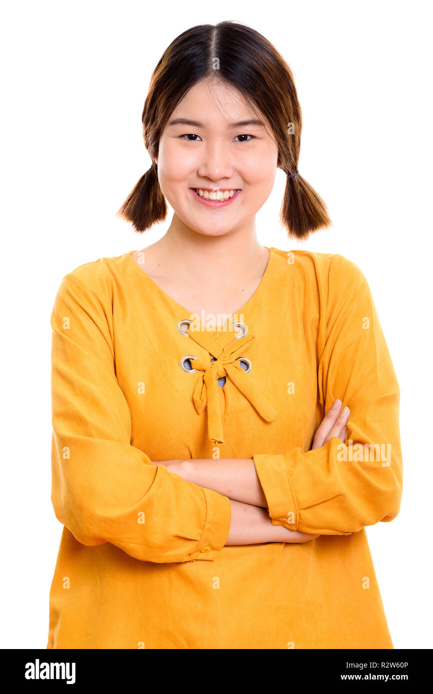 Studio shot of young happy Asian woman smiling with arms crossed Banque D'Images