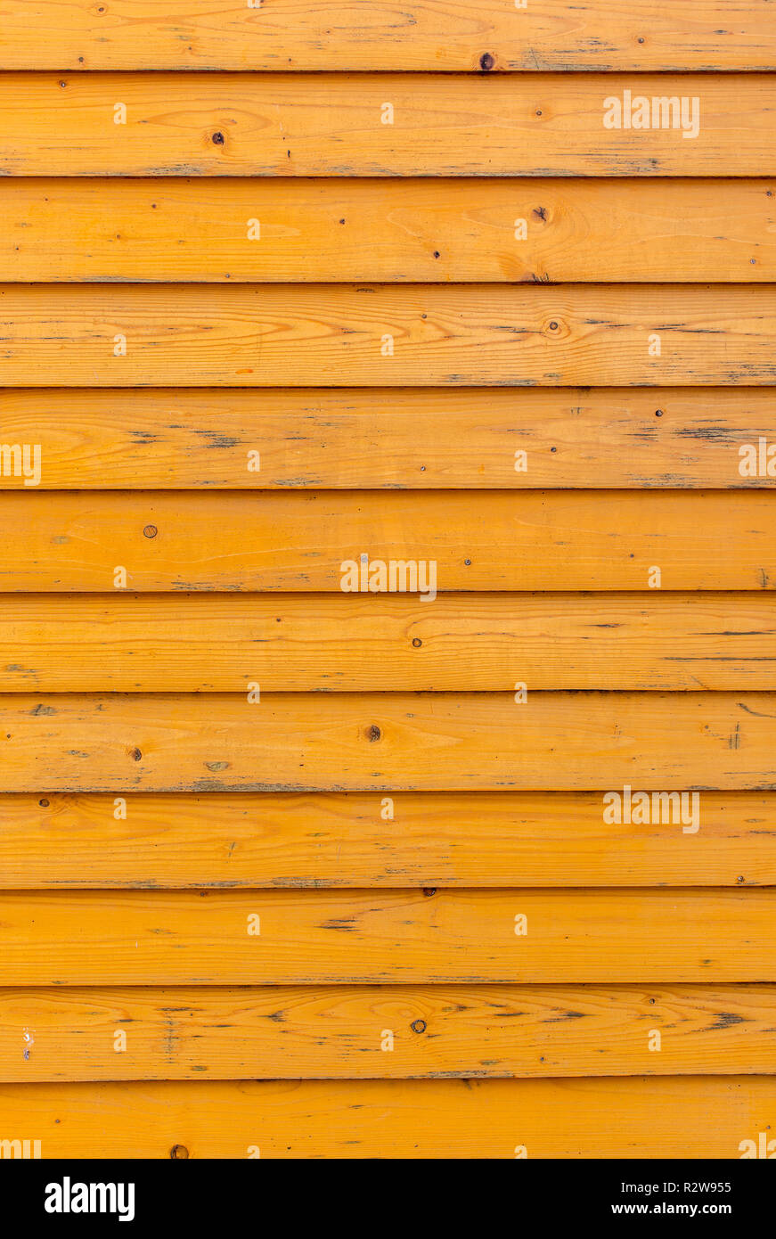 Vieille clôture en bois horizontal arrière-plan. Vieilles planches en bois avec de la peinture jaune vif. Photo verticale Banque D'Images