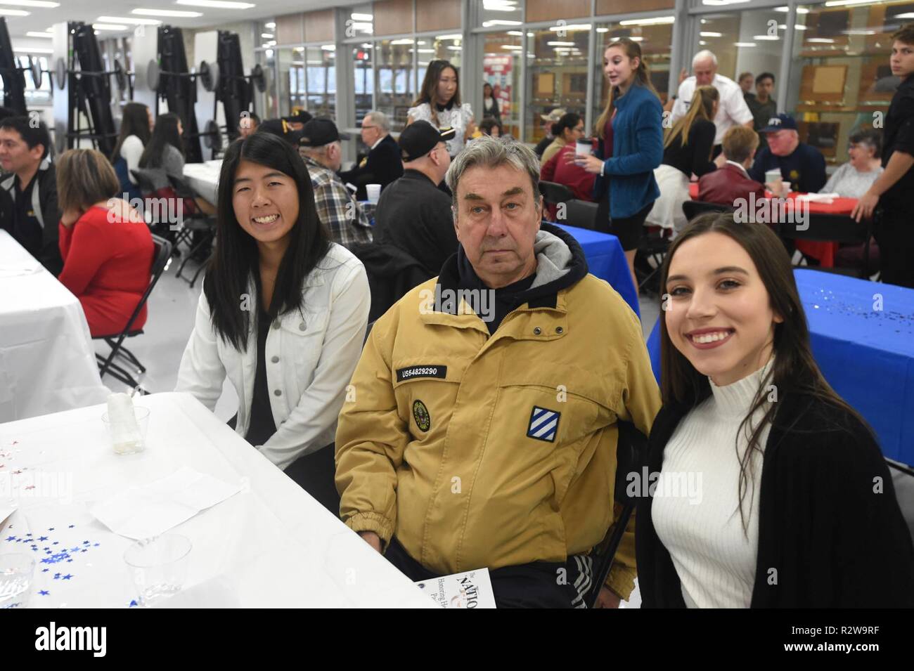 Philippe Schubitz, centre, à l'époque du Vietnam ancien combattant ayant servi avec l'armée américaine de 1968 à 1970, s'arrête pour une photo avec Lauren étudiant l'APD (à gauche) et Jessica, Pavliukovecas au cours de l'Elk Grove High School de la cérémonie de la Journée des anciens combattants, le 9 novembre 2018. Réserve de l'armée américaine Brig. Le général Kris A. Bélanger, général commandant, 85e en charge la commande, était le conférencier invité pour l'événement et a assisté à des anciens combattants de chacune des branches de services pour inclure un ancien combattant de la Seconde Guerre mondiale, Al Mampre, qui ont servi à la célèbre 101st Airborne Division est facile Company, 506e Régiment d'infanterie. L'unité du Mampre story a été présenté sur Banque D'Images