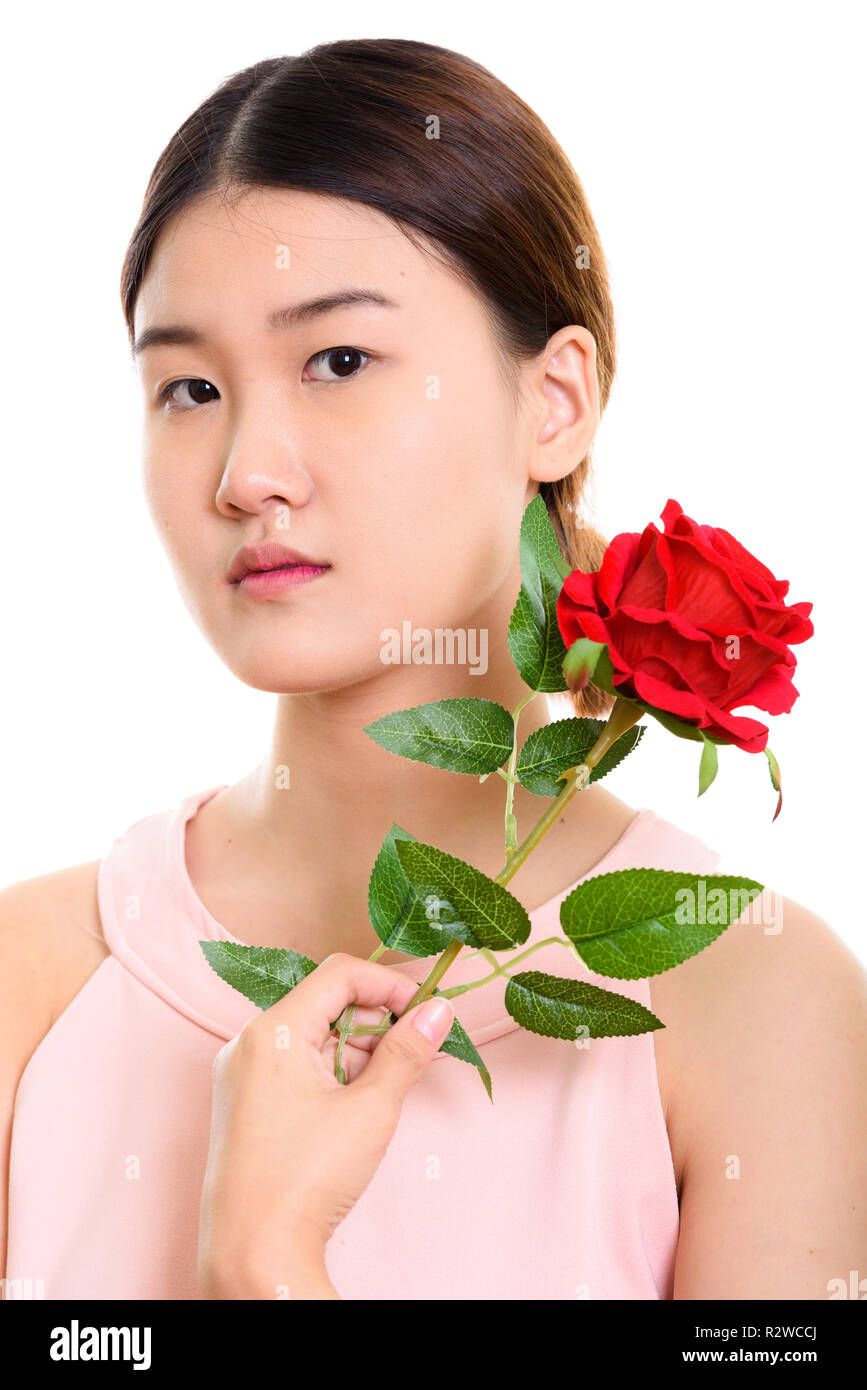 Close up of young beautiful Asian woman holding rose rouge près de th Banque D'Images