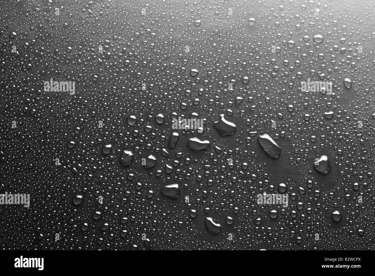 Gouttes d'eau sur un verre foncé texture background Banque D'Images