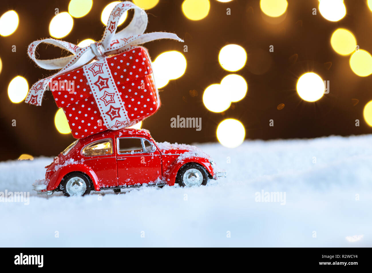 Voiture rouge de Noël avec boîte-cadeau sur la neige Banque D'Images