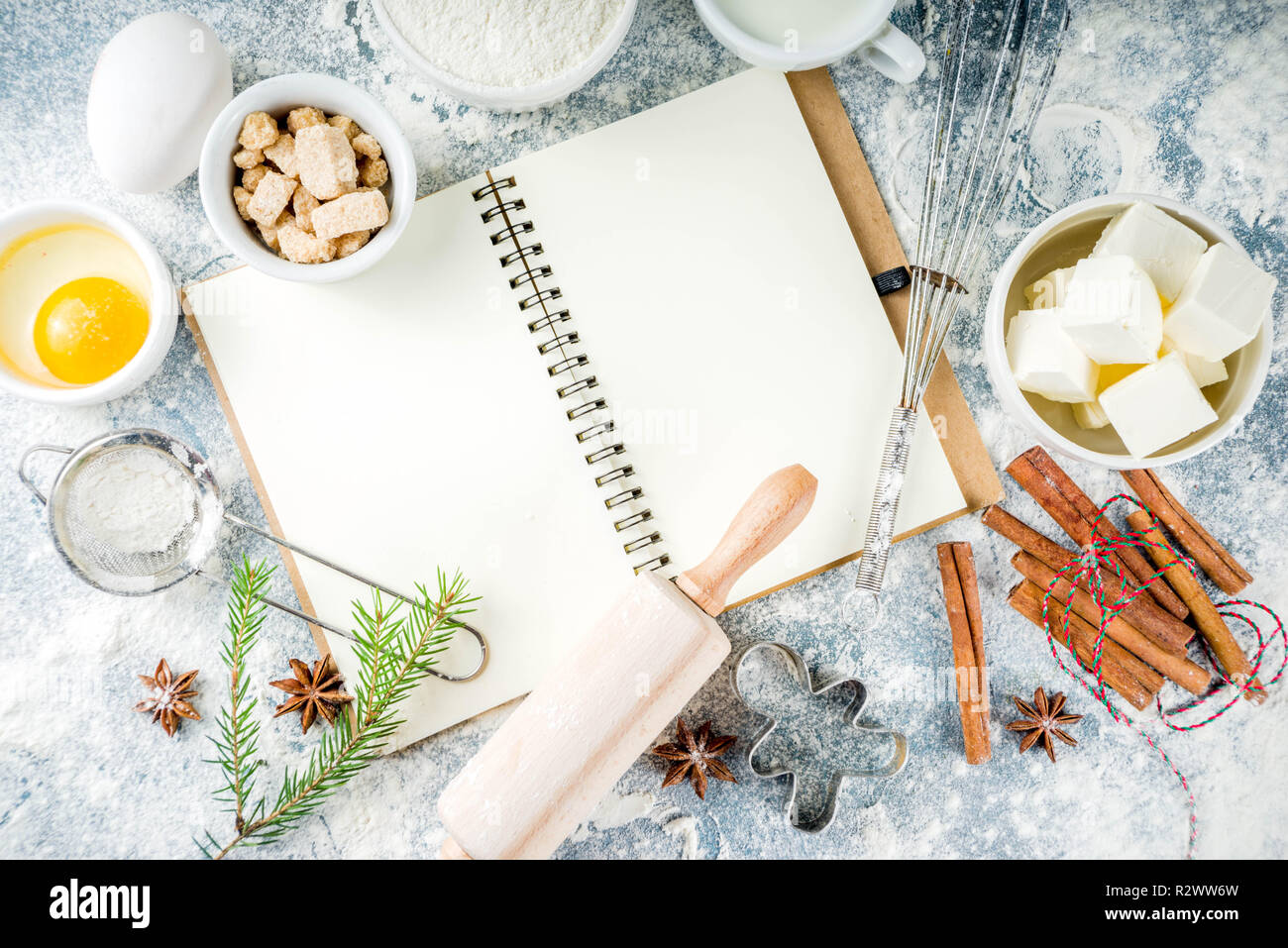 L'hiver et Noël arrière-plan de cuisson. Des ustensiles de cuisine et les ingrédients pour la cuisson la boulangerie - farine, sucre, œufs, beurre, lait, cannelle, fouetter Banque D'Images