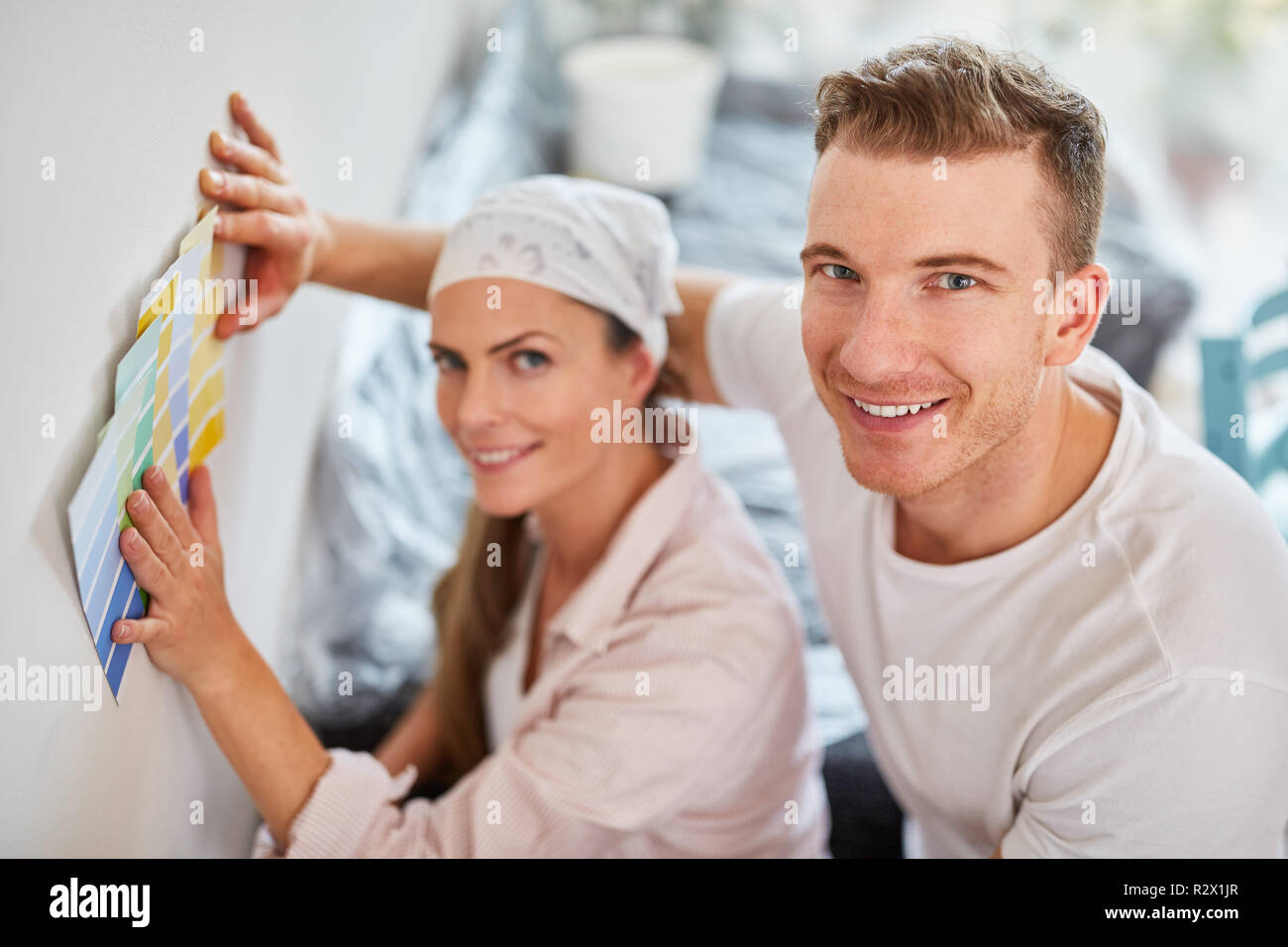 Jeune couple rénover avec échantillons de couleur à la recherche de couleur du mur de droite Banque D'Images