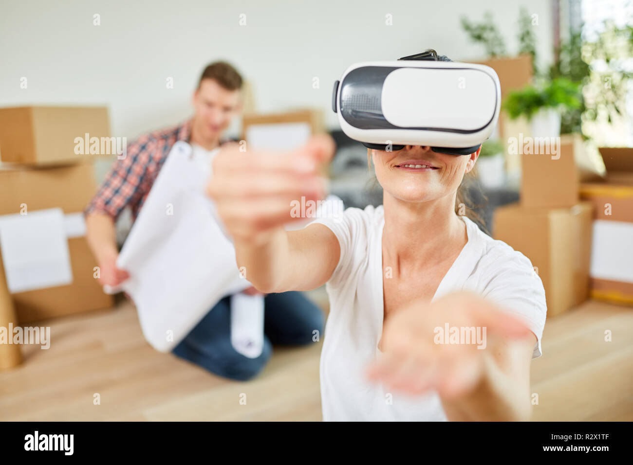 Jeune femme utilise des lunettes de réalité virtuelle dans le nouvel appartement à la planification de l'espace Banque D'Images