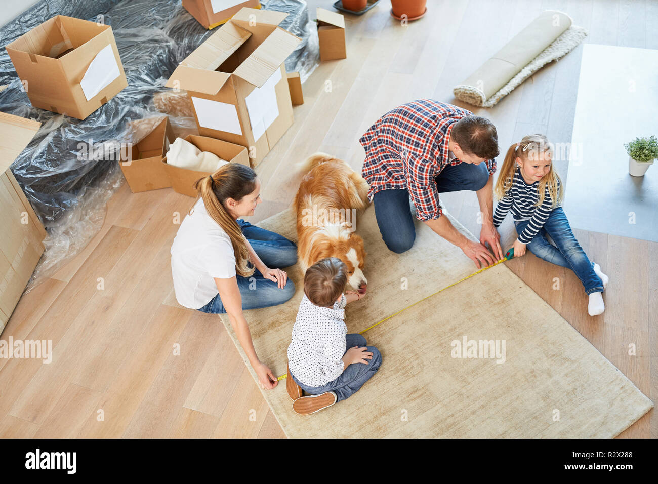 Parents et enfants mesurer un tapis dans la conception de chambre dans la nouvelle maison Banque D'Images