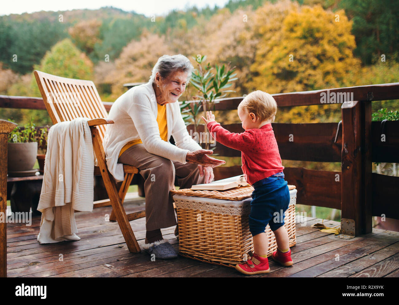 Vieille Femme avec un enfant en arrière-petits sur une terrasse à l'automne. Banque D'Images