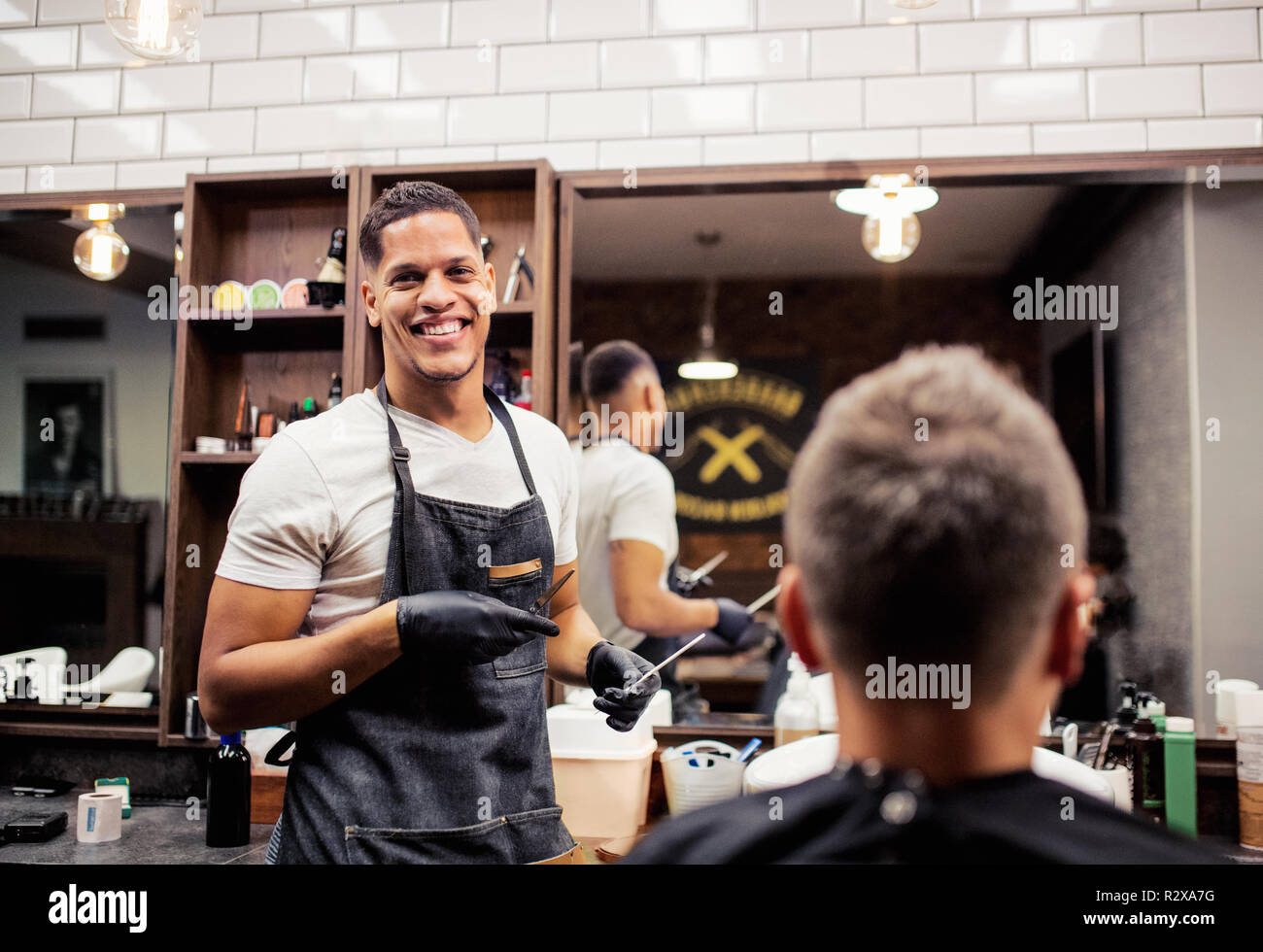 Vue arrière de l'homme visite client et coiffeurs coiffeur dans un salon de coiffure. Banque D'Images