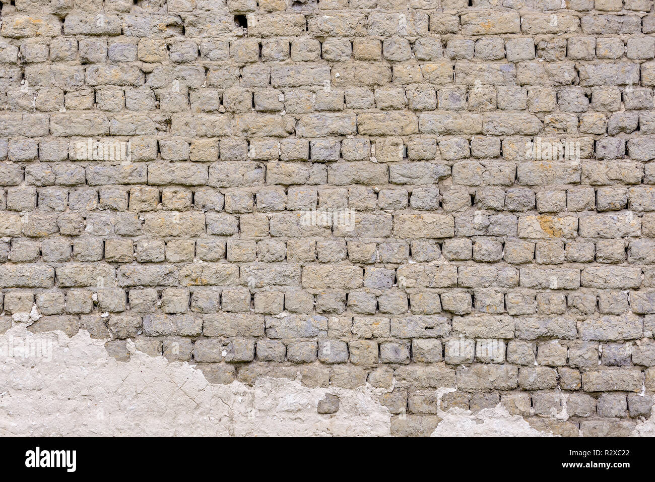 Vieux millésime mur de brique gris avec des traces de plâtre blanc Banque D'Images