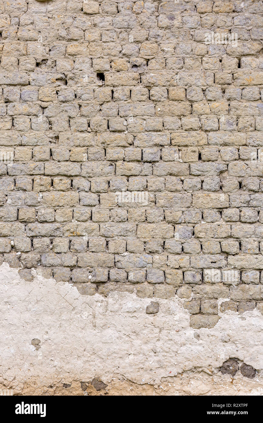 Vieux millésime mur de brique gris avec des traces de plâtre blanc. Photo verticale Banque D'Images