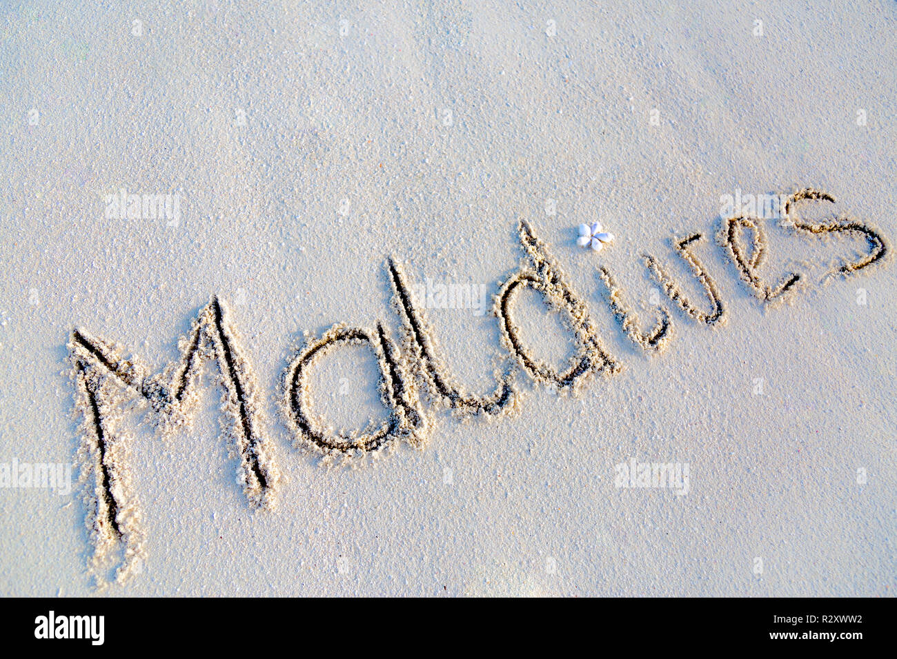Maldives texte écrire dans le sable blanc, regarde 3D texture arrière-plan et l'espace de copie Banque D'Images