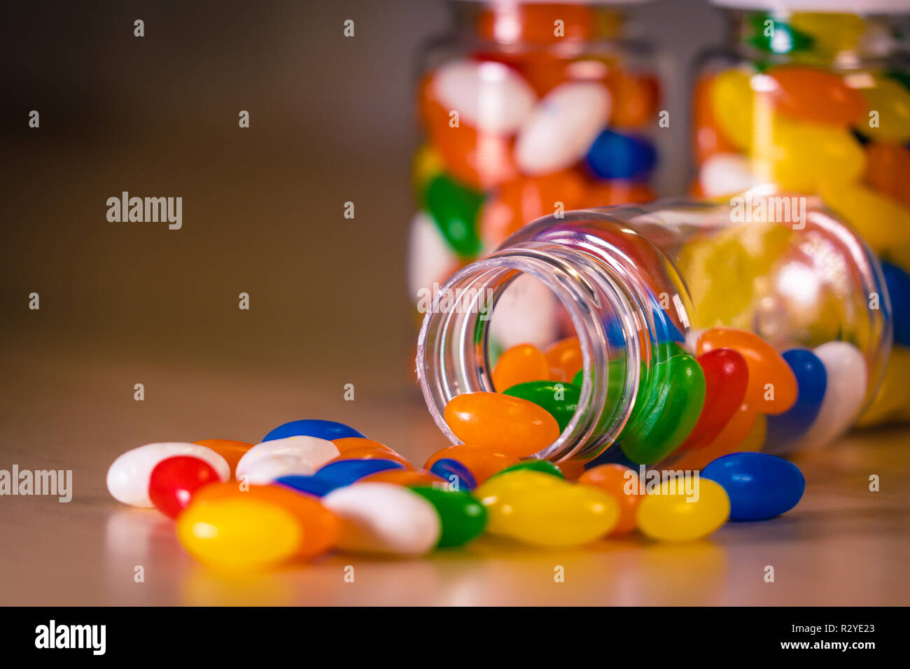 Pilules multicolores s'échappant d'une bouteille de pilules contre un arrière-plan flou Banque D'Images