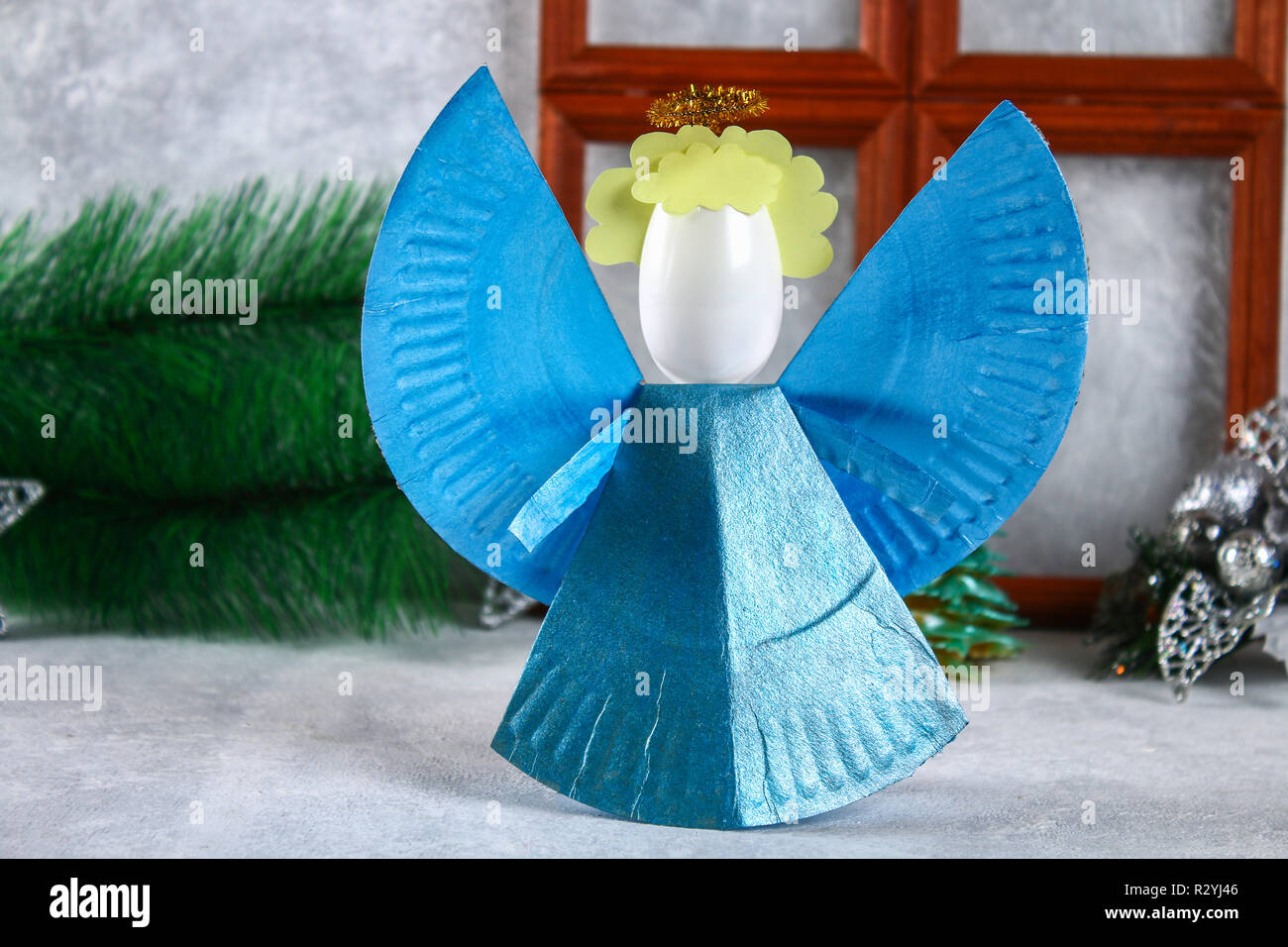 Le processus de création de votre propre ange de Noël à partir d'une plaque  de carton à usage unique, une cuillère en plastique et papier. Décoration  de Noël. Faits à la main,