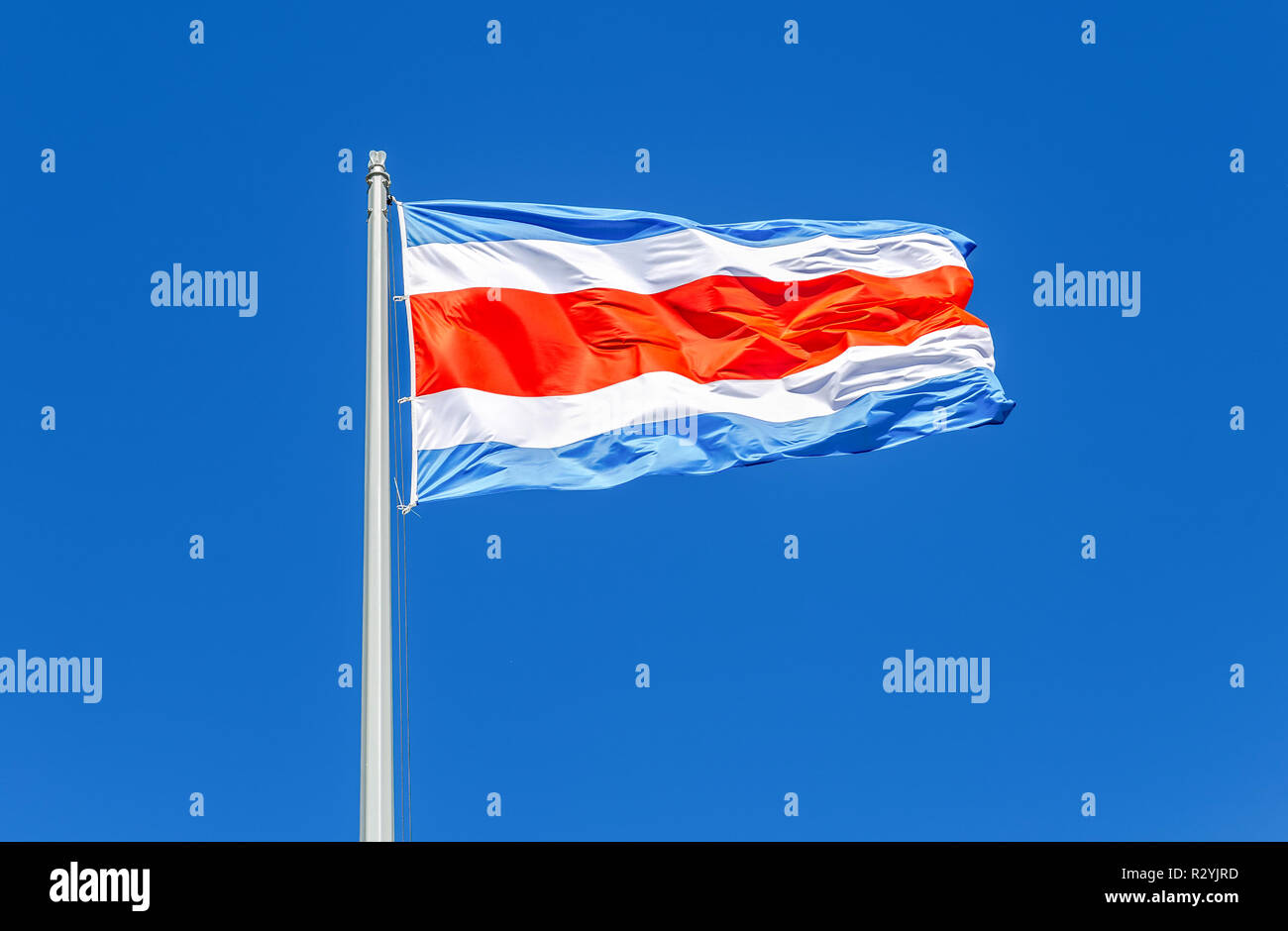 Drapeau national du Costa Rica et ondulant dans le vent contre le ciel bleu Banque D'Images