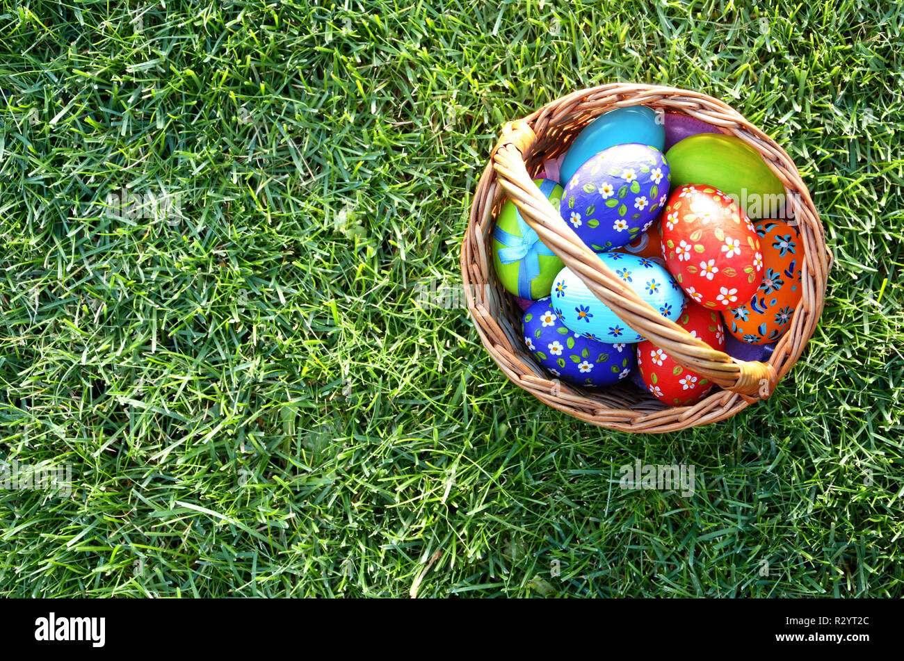 Télévision jeter coup d'œufs de Pâques dans le panier en osier sur green spring grass Banque D'Images
