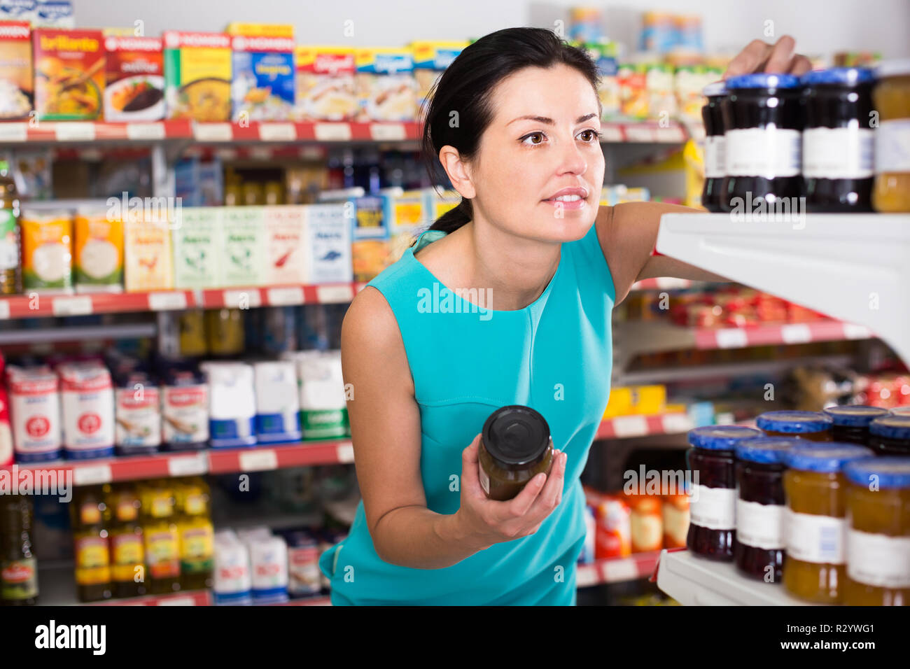 Portrait de femme adulte sur la boutique holding conservé pot de confiture Banque D'Images
