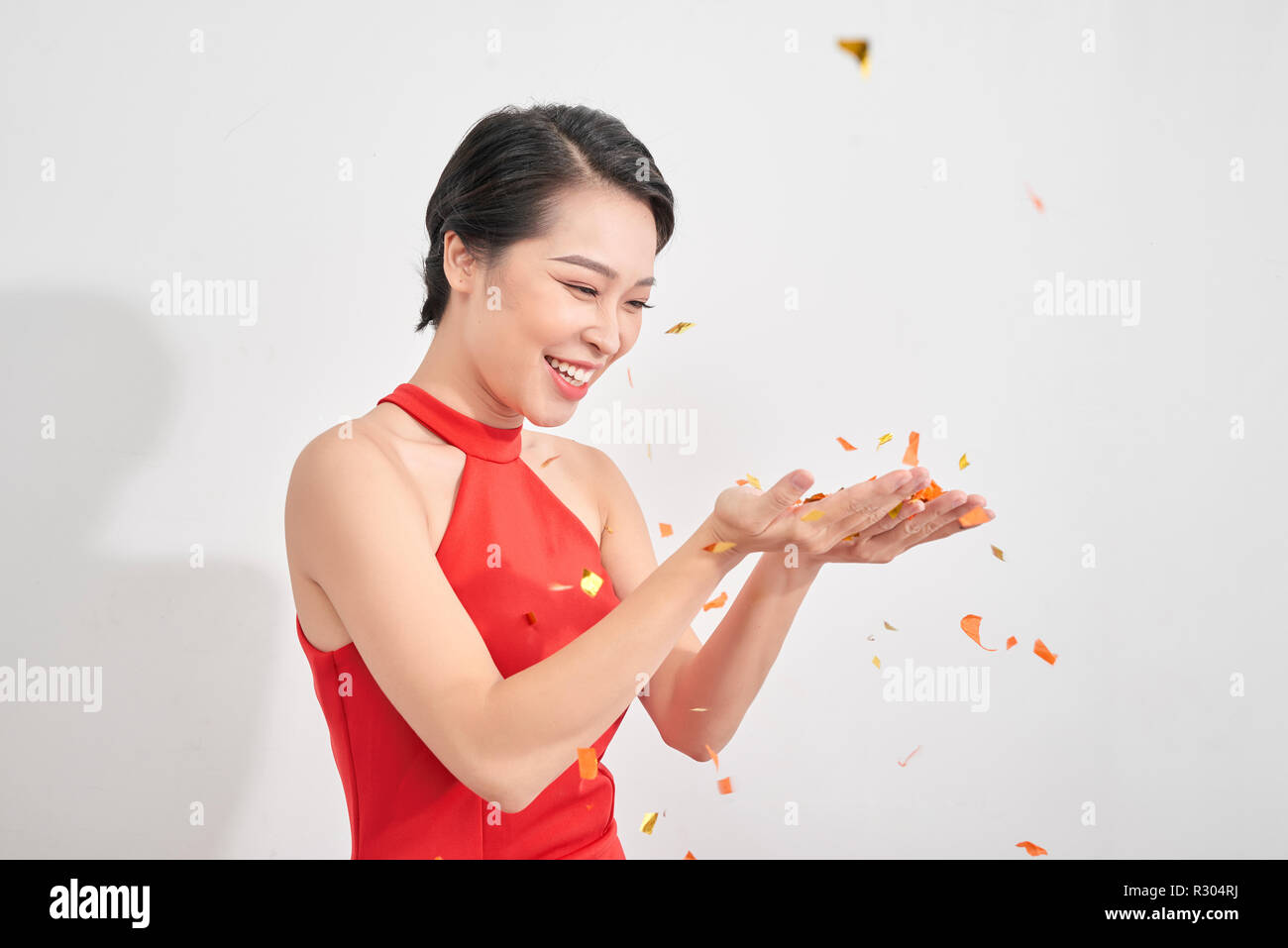 Portrait d'une belle fille robe porter en vertu de l'article pluie de confettis et de célébrer isolated over white background Banque D'Images