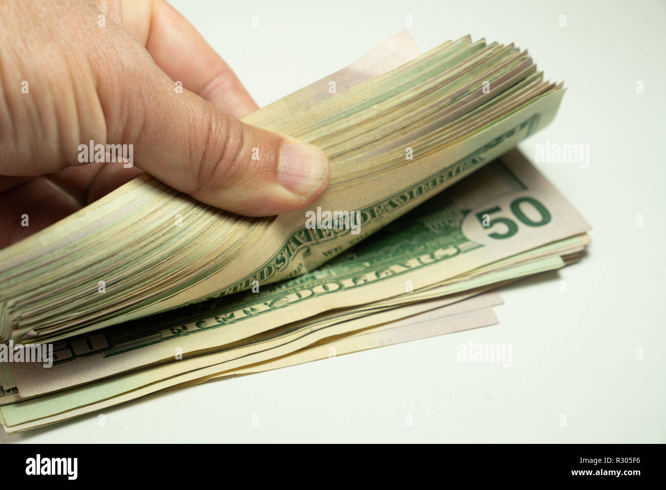 Dollars en espèces se trouvant dans l'avion. Le comptage à main US Dollar bills ou payer en espèces. Banque D'Images