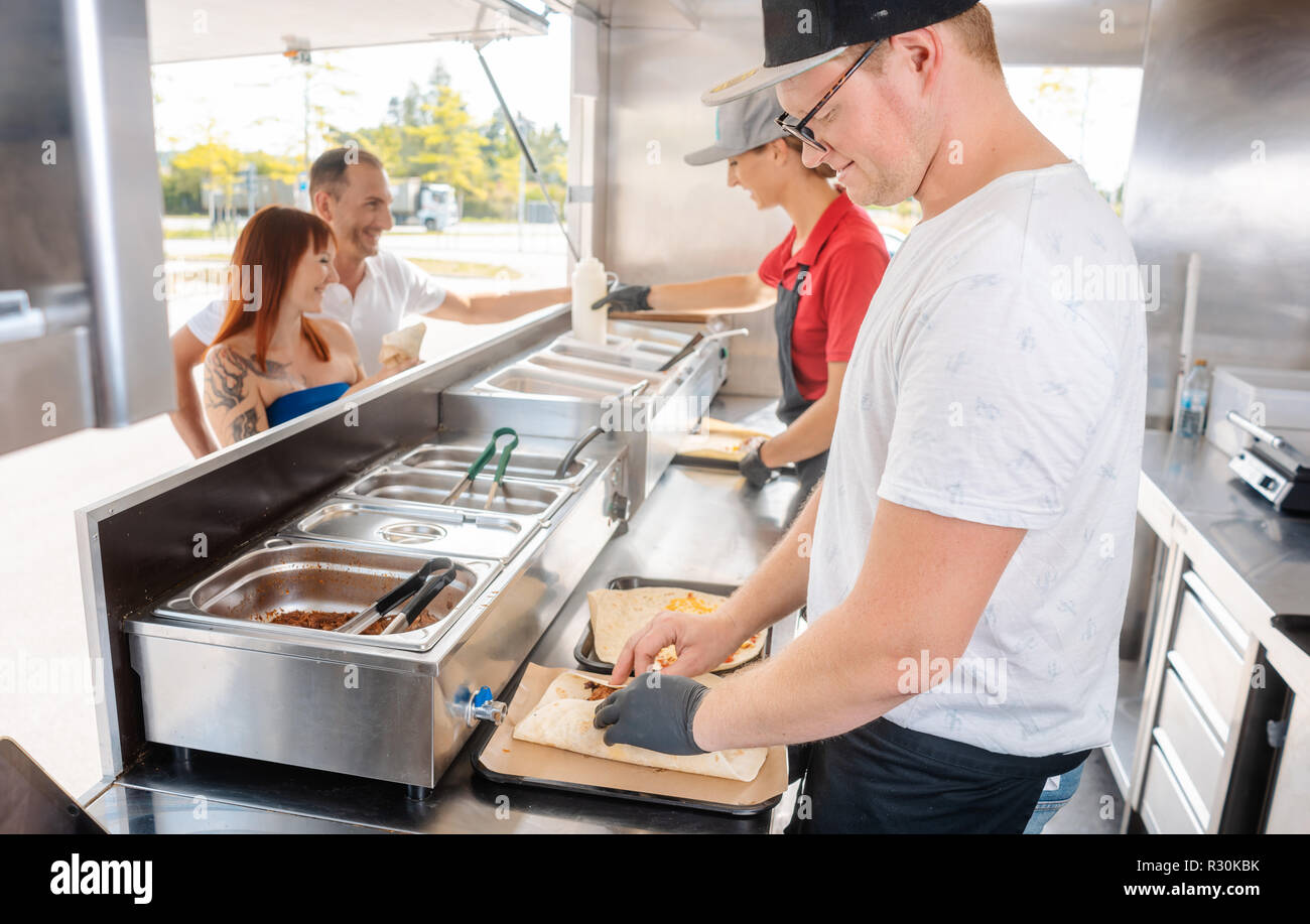 Les jeunes cuisiniers dans un camion alimentaire la préparation des aliments Banque D'Images