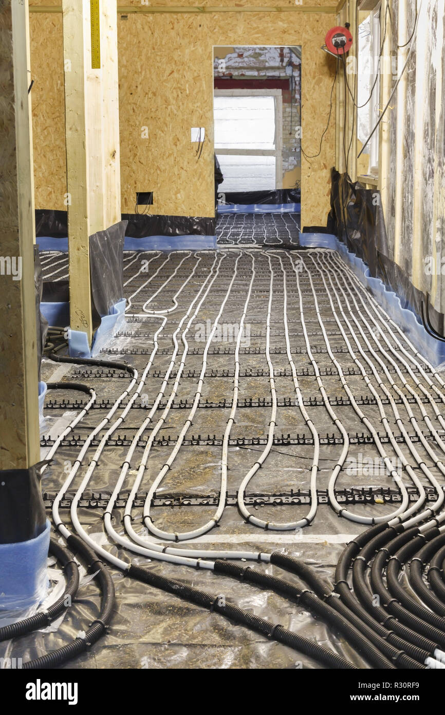 Chauffage au sol installation de conduites d'eau sur le sous-plancher d'une maison en construction Banque D'Images