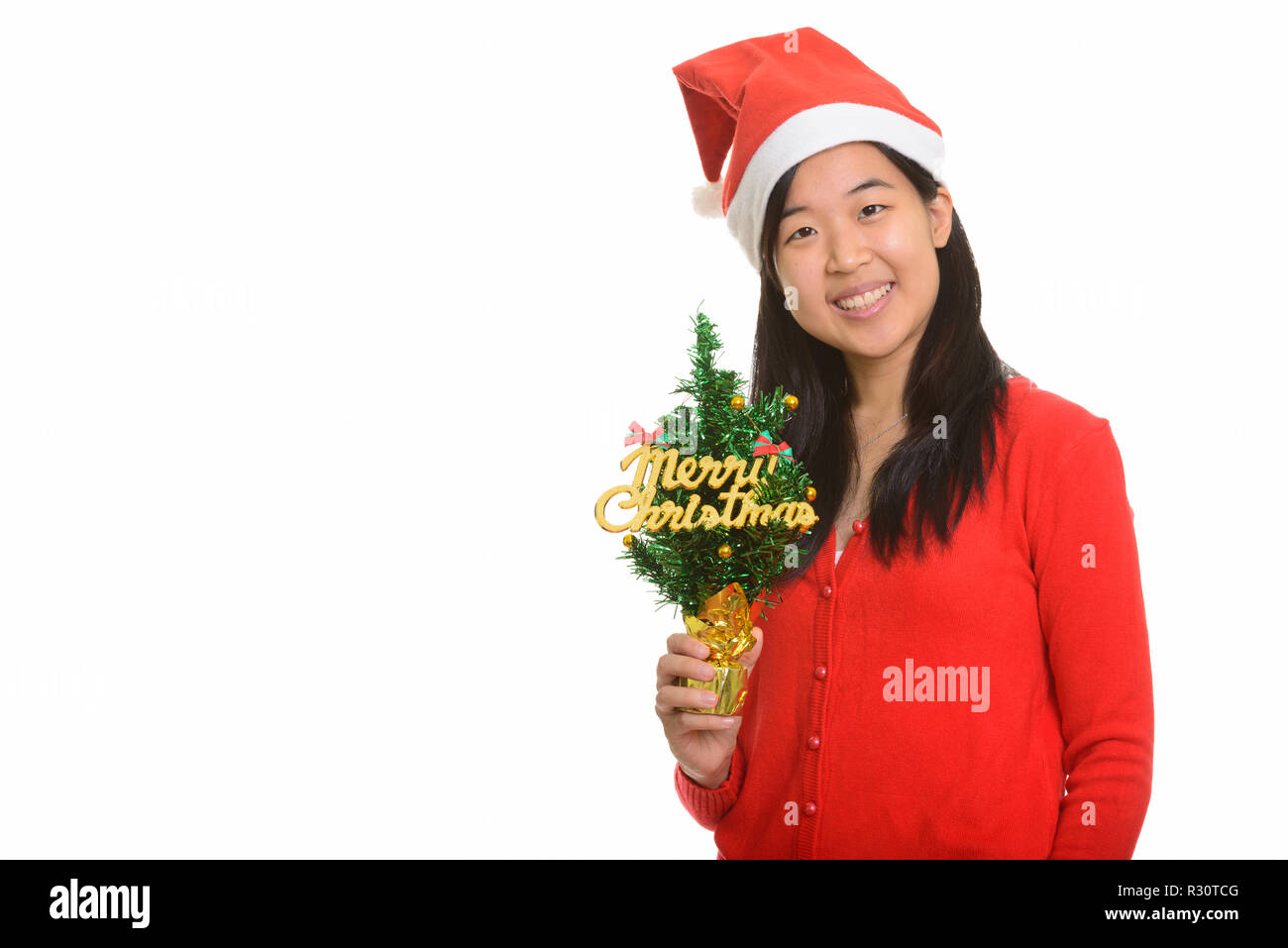Young happy Asian woman holding Merry Christmas Tree prêt pour C Banque D'Images