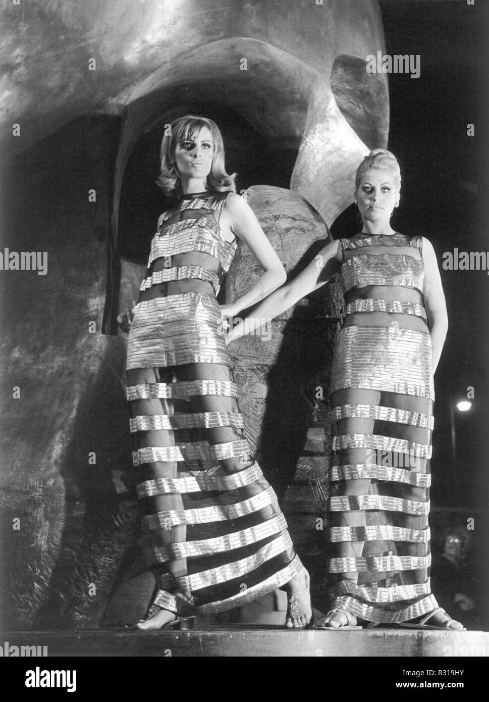 Présenter deux modèles de robes du soir avec des bandes métalliques à un défilé de nuit le 26 juin 1967 dans le Bildgießerei Noak à Berlin-Wilmersdorf. Dans l'arrière-plan la sculpture 'Atom' partie par le sculpteur britannique Henry Moore. Le défilé a eu lieu à l'occasion de la XVII Festival International du Film de Berlin et a montré les créations du jeune designer de mode Machnik de Berlin. Dans le monde d'utilisation | Banque D'Images