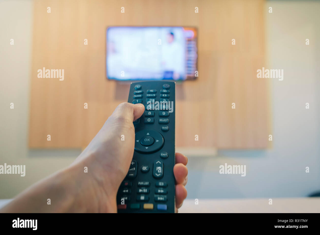 Main Tenant Une Television Avec Telecommande Ob Lit Avec Television Brouillee Close Up Photo Stock Alamy